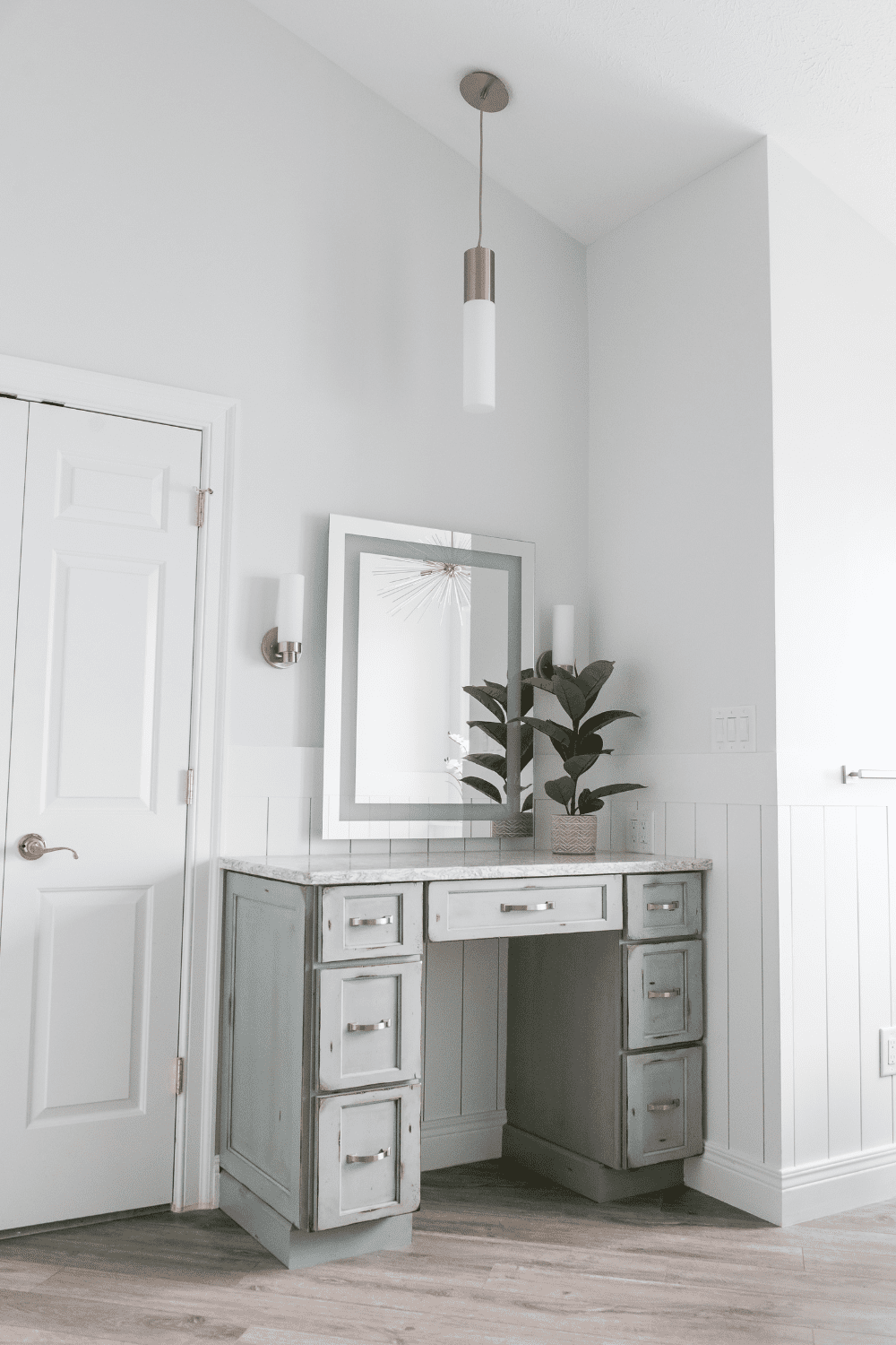 Nicholas Design Build | A white vanity in a master bathroom with wood floors.