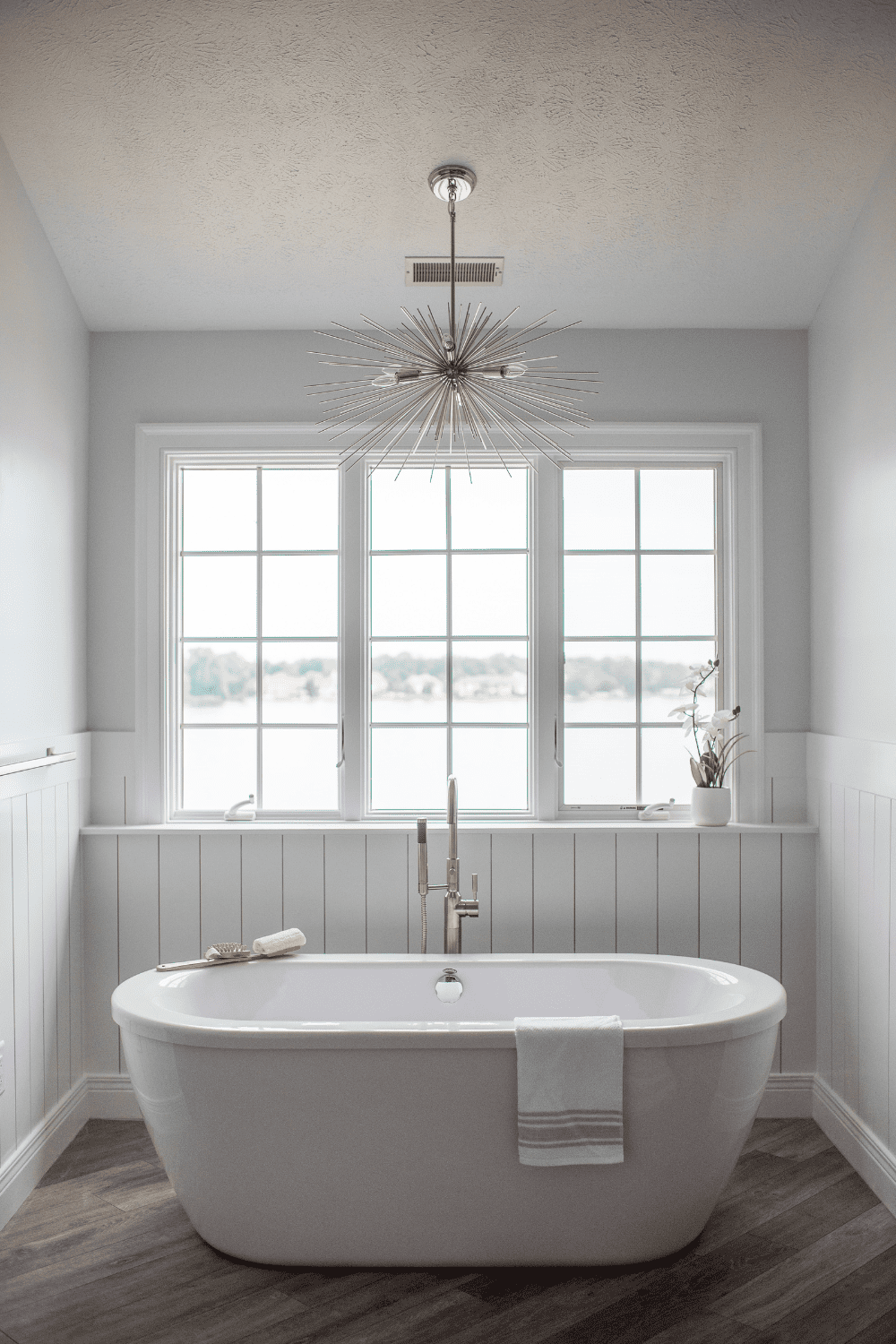 Nicholas Design Build | A white bathtub in a master bathroom remodel with wood floors.