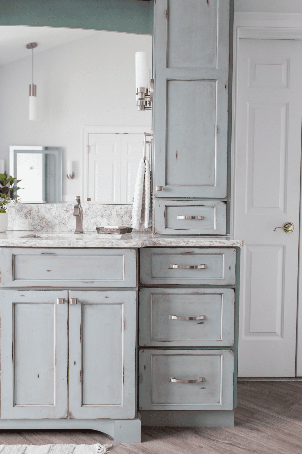 Nicholas Design Build | A master bathroom remodel with blue cabinets and a mirror.