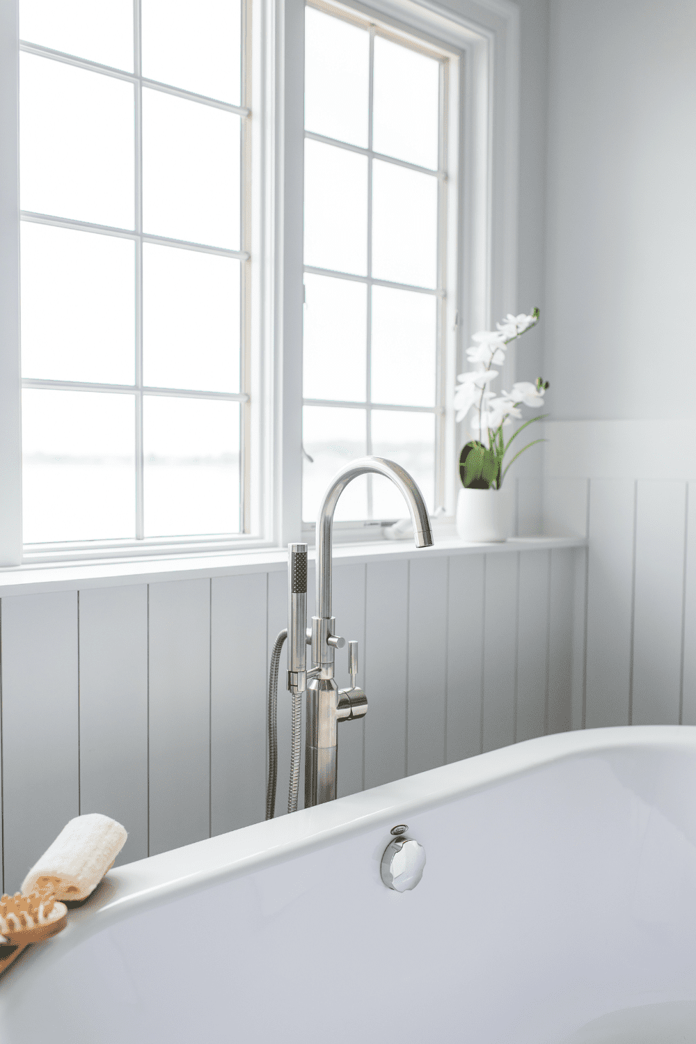Nicholas Design Build | A white bathtub in a master bathroom with a window.