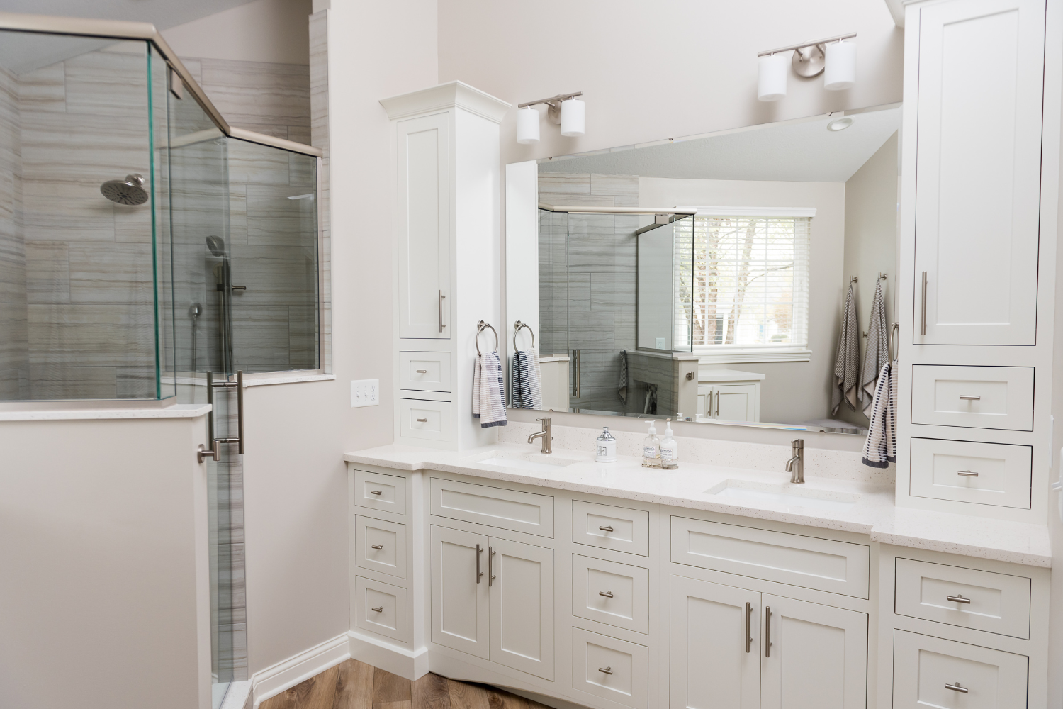 Nicholas Design Build | A bathroom remodel with white cabinets and a walk in shower.