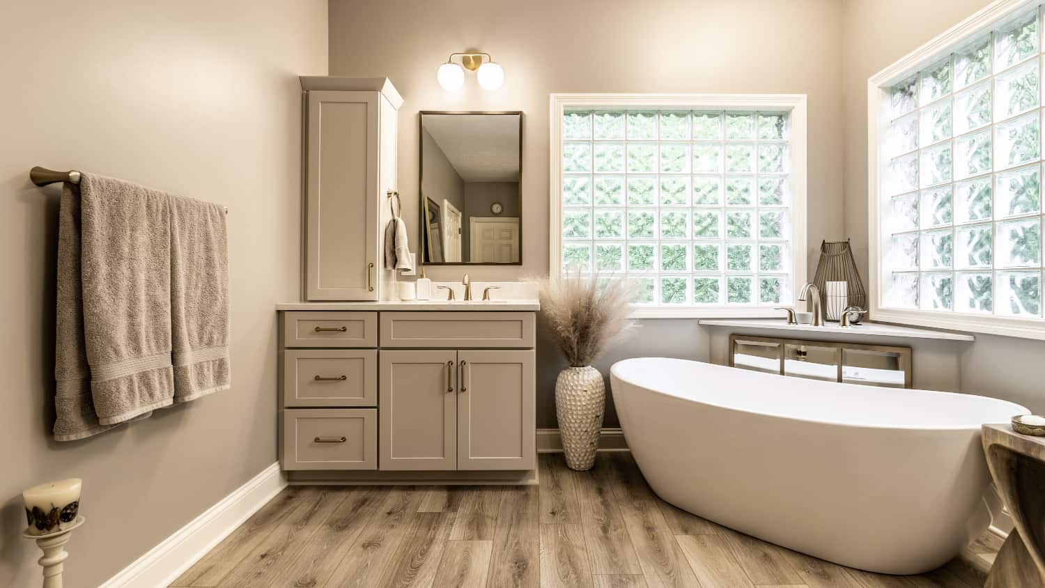 Nicholas Design Build | A modern bathroom with a white tub and hardwood floors.
