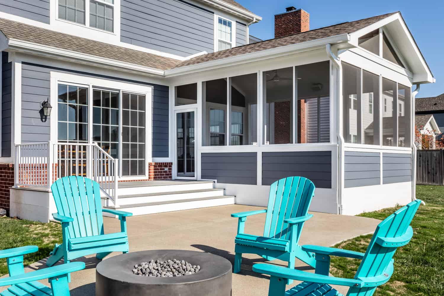 Nicholas Design Build | Remodel a patio with blue chairs and a fire pit.