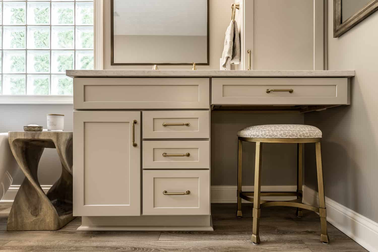 Nicholas Design Build | A modern bathroom with a stylish vanity and a sleek brushed gold stool.