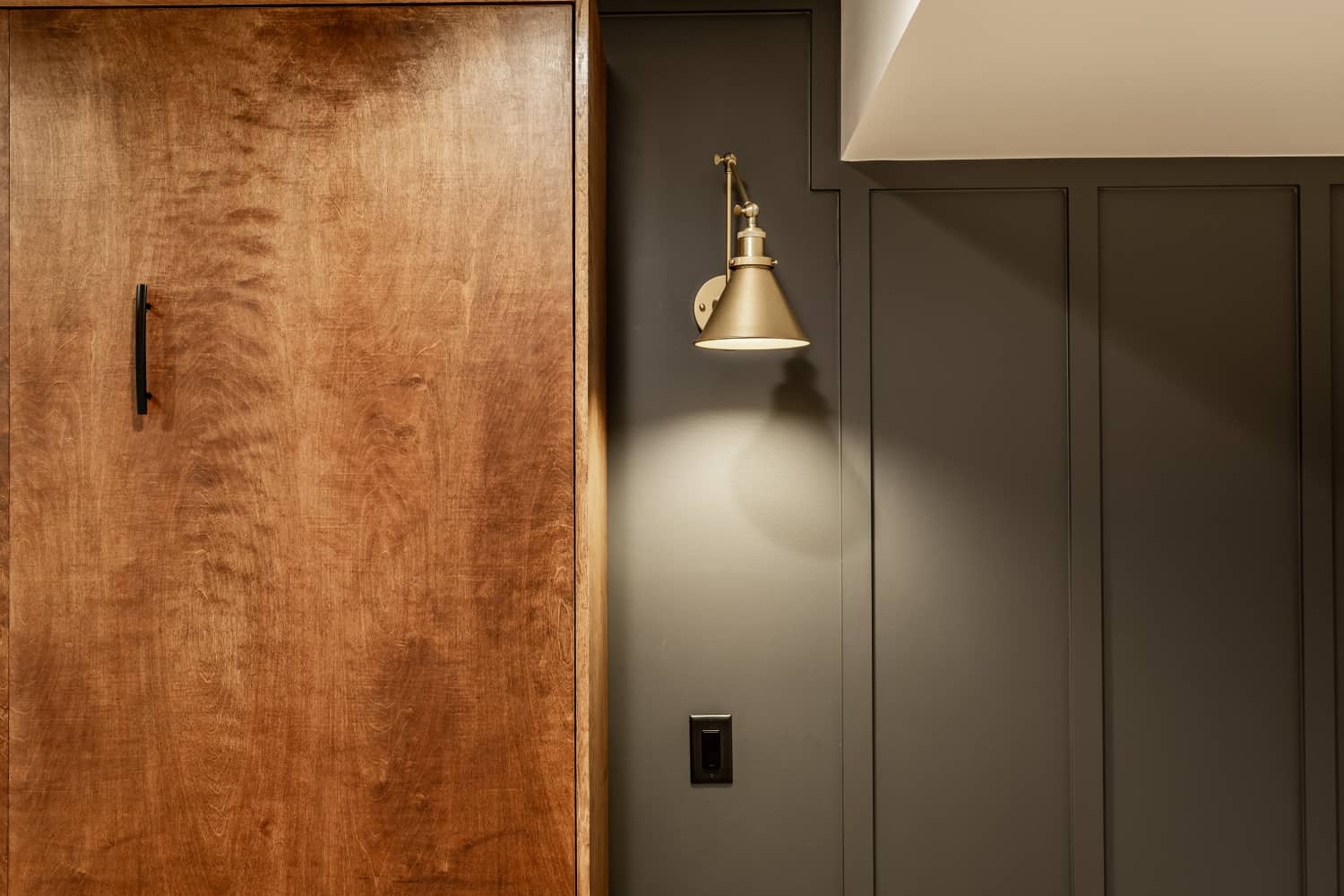 Nicholas Design Build | A remodel of a wooden door with a light on it in a dark room.