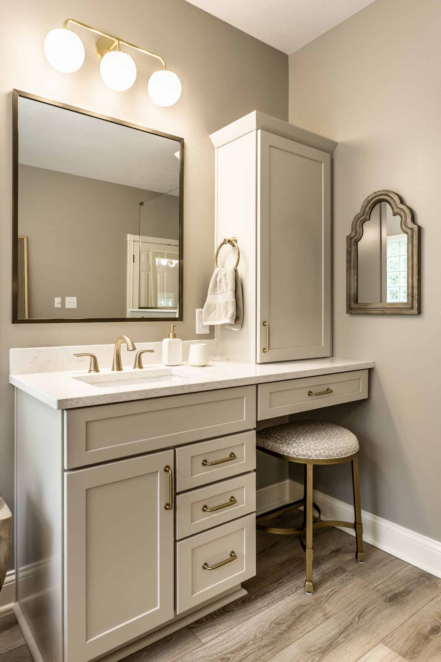 Nicholas Design Build | A modern bathroom with a vanity, sink, and mirror in brushed gold.