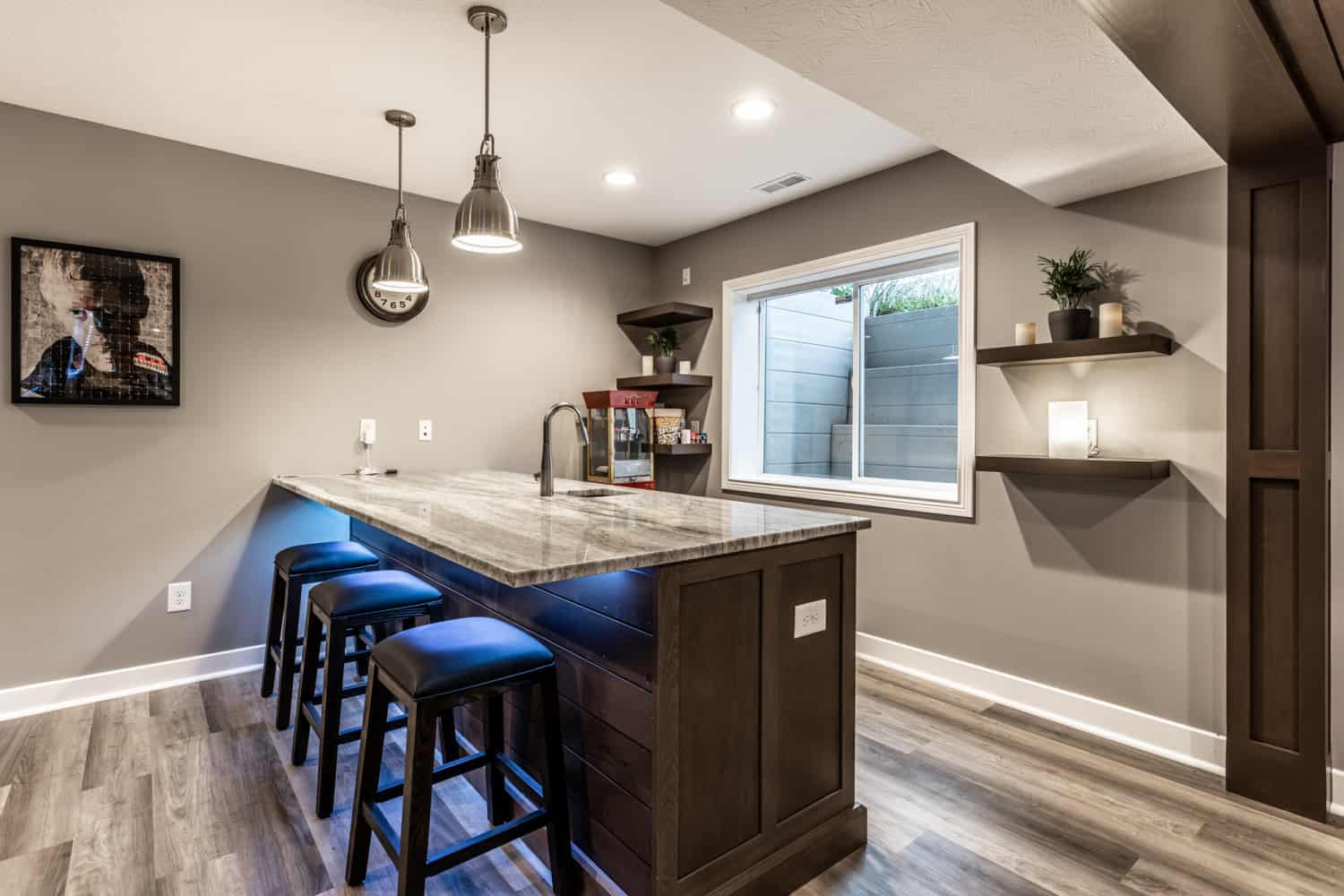 Nicholas Design Build | A kitchen with bar stools and wood floors.