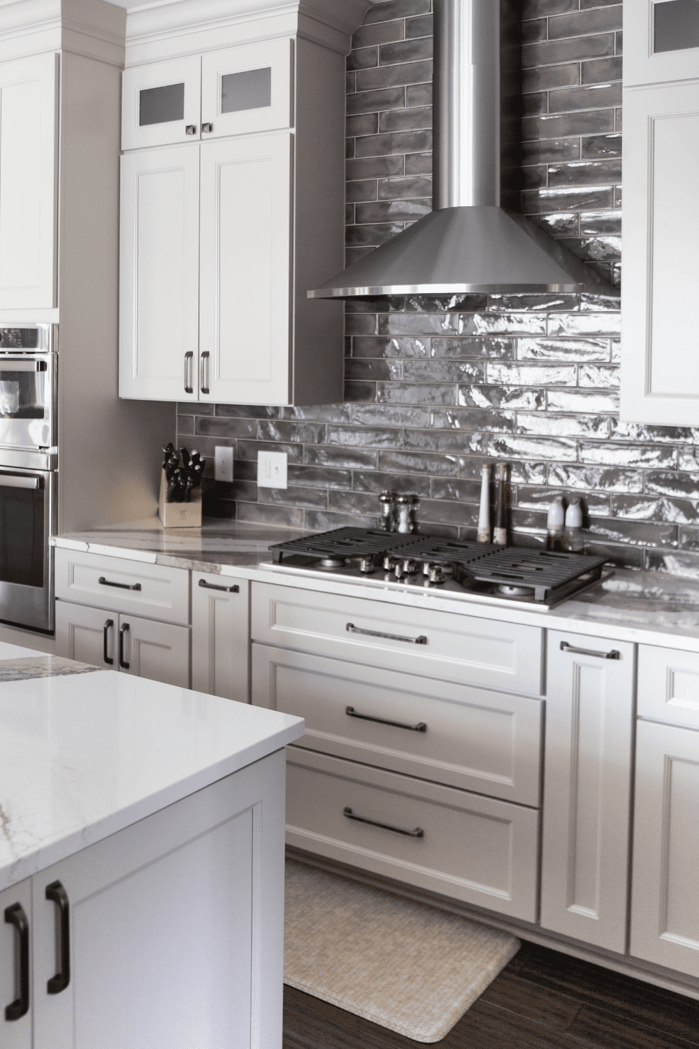 Nicholas Design Build | A white kitchen with marble counter tops.