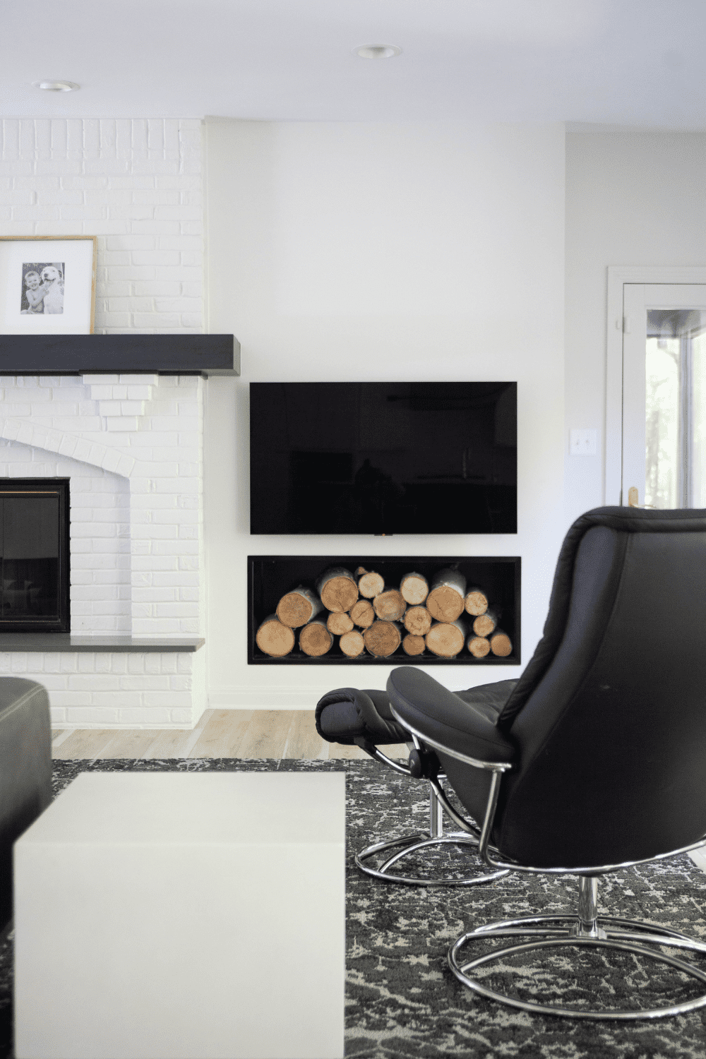 Nicholas Design Build | A living room with a fireplace and a black chair.