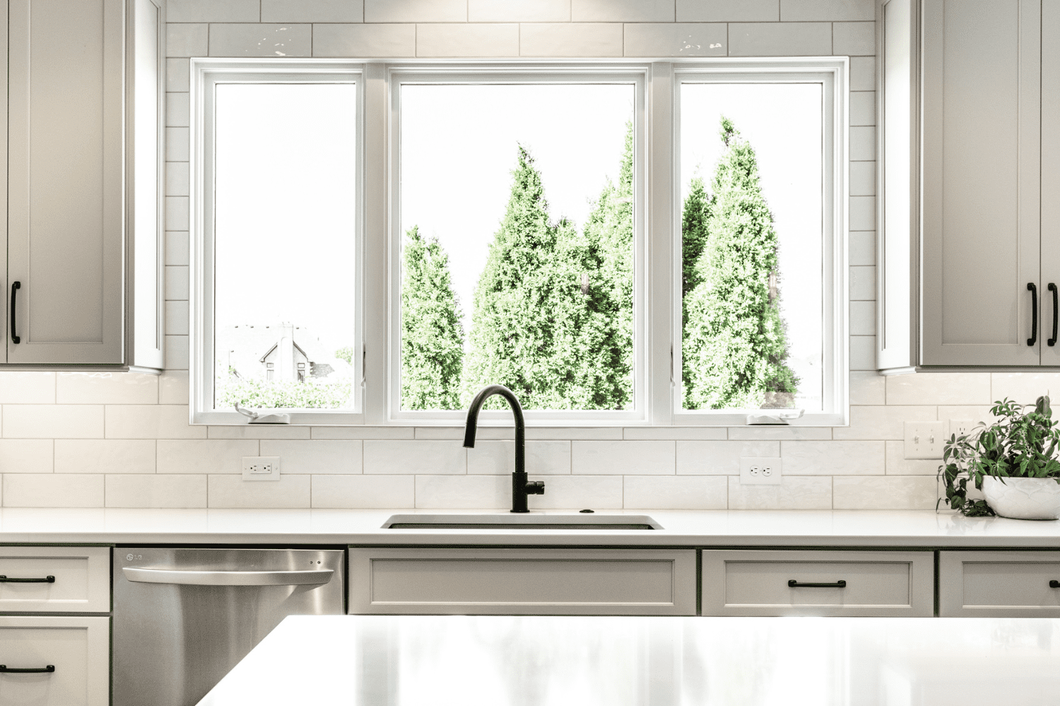 Nicholas Design Build | A kitchen with white cabinets and a window.