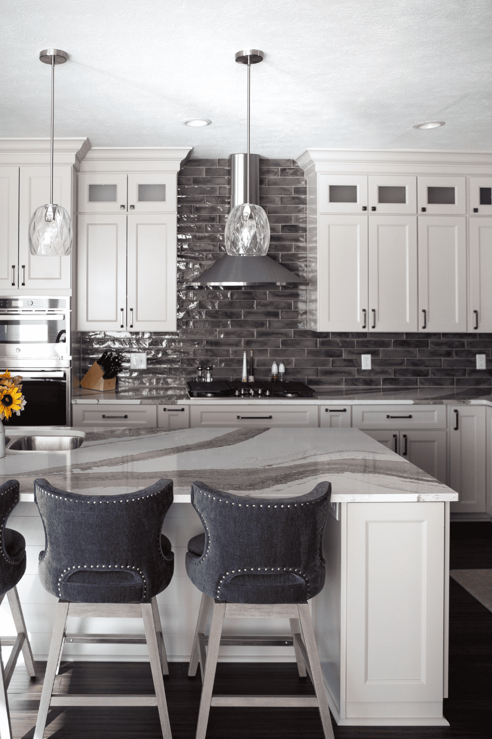 Nicholas Design Build | A kitchen with white cabinets and a center island.