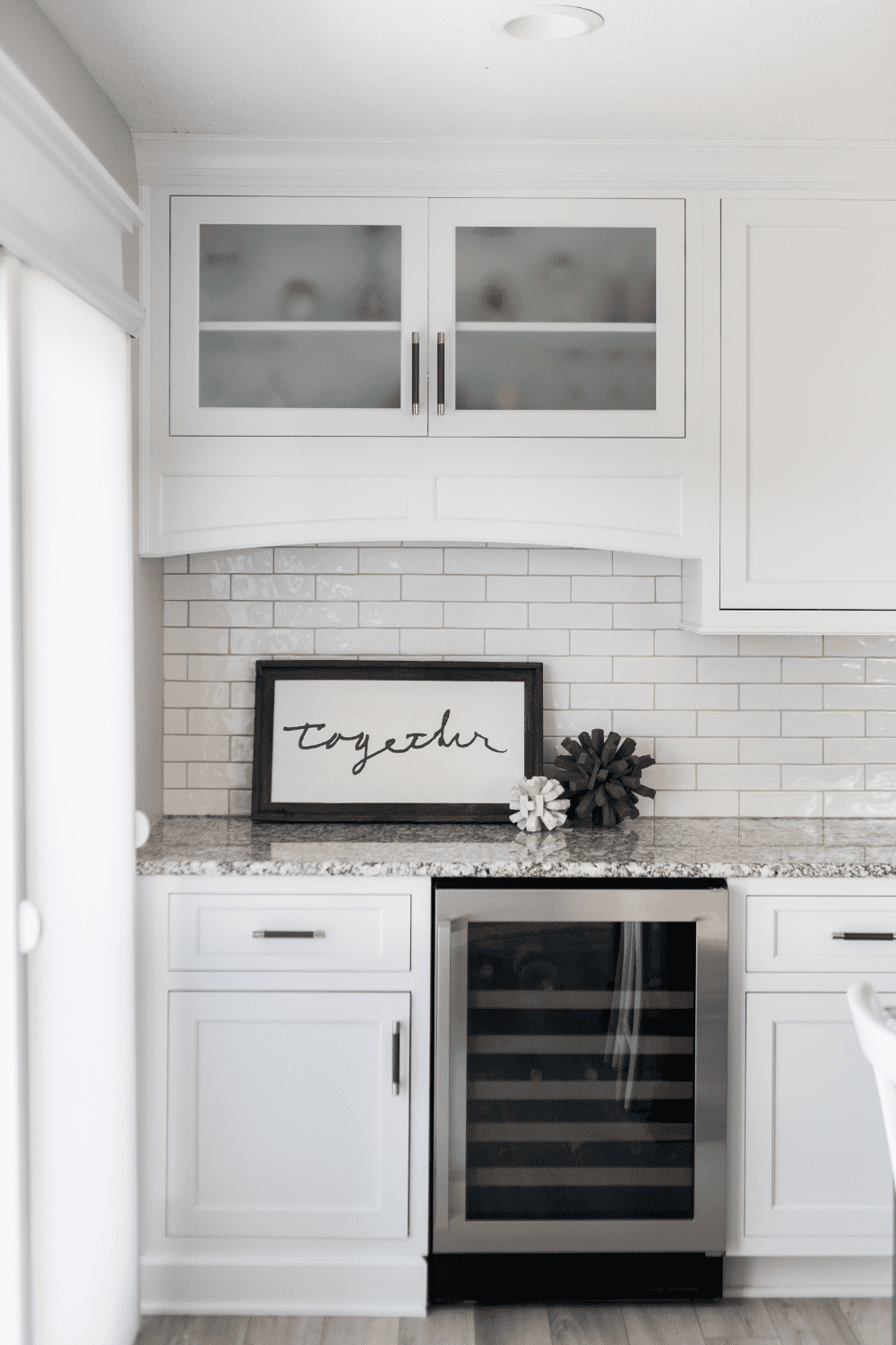 Nicholas Design Build | A kitchen with white cabinets and a wine rack.