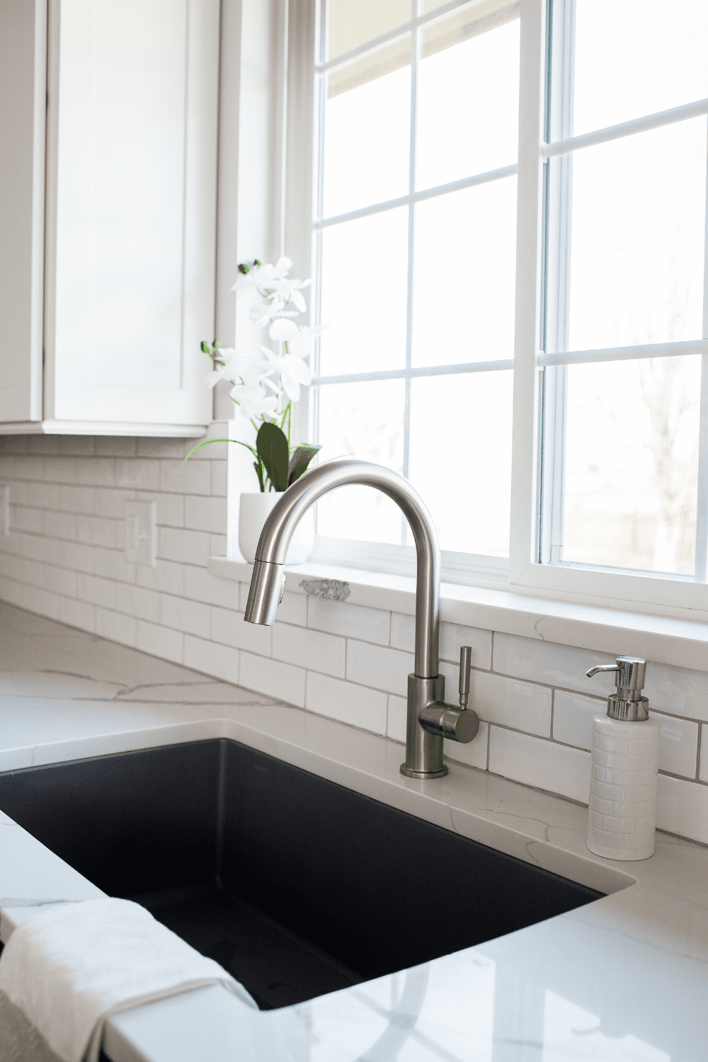 Nicholas Design Build | A white kitchen with a black sink.