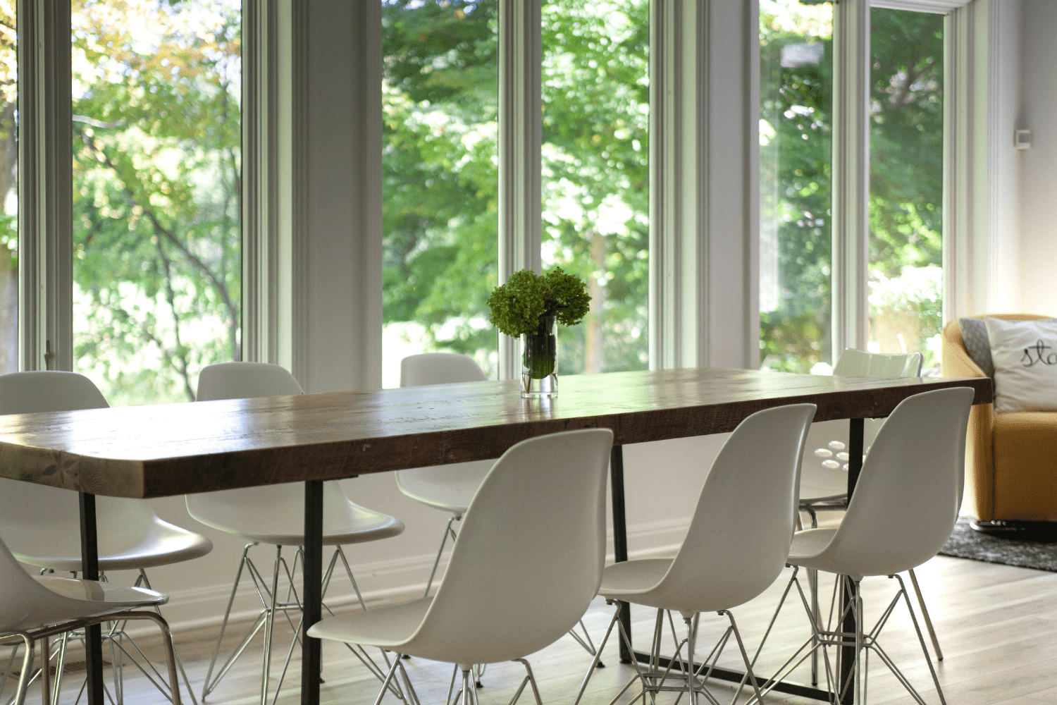 Nicholas Design Build | A dining room with white chairs and large windows.