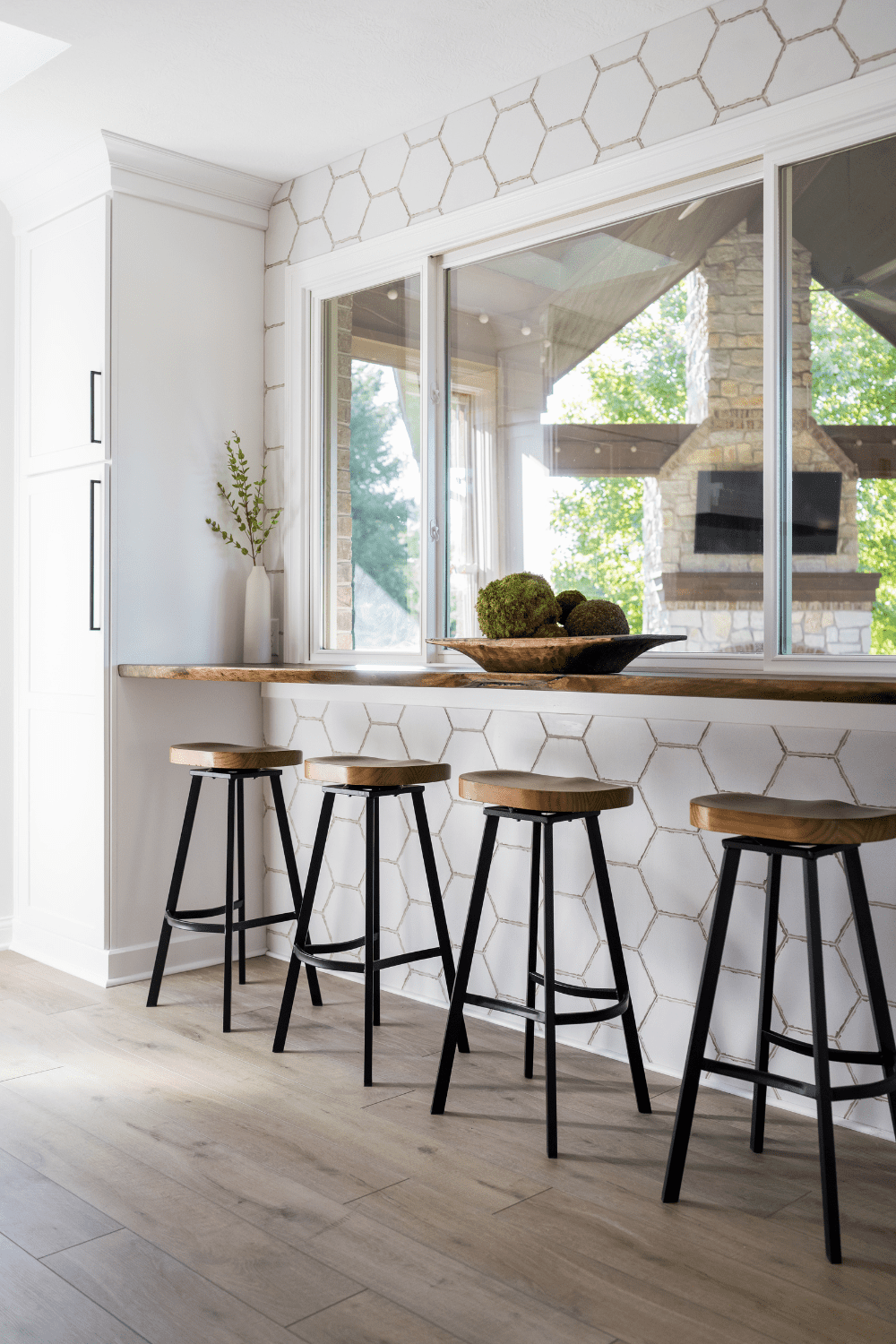 Nicholas Design Build | A kitchen with bar stools and a window.