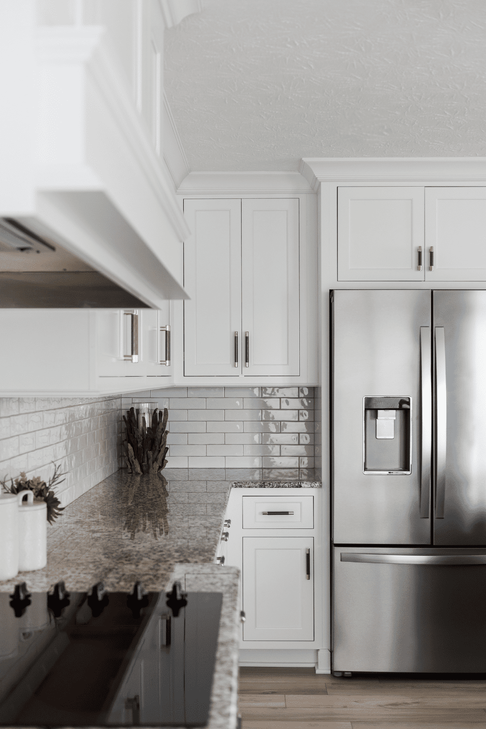 Nicholas Design Build | A white kitchen with a stainless steel refrigerator.