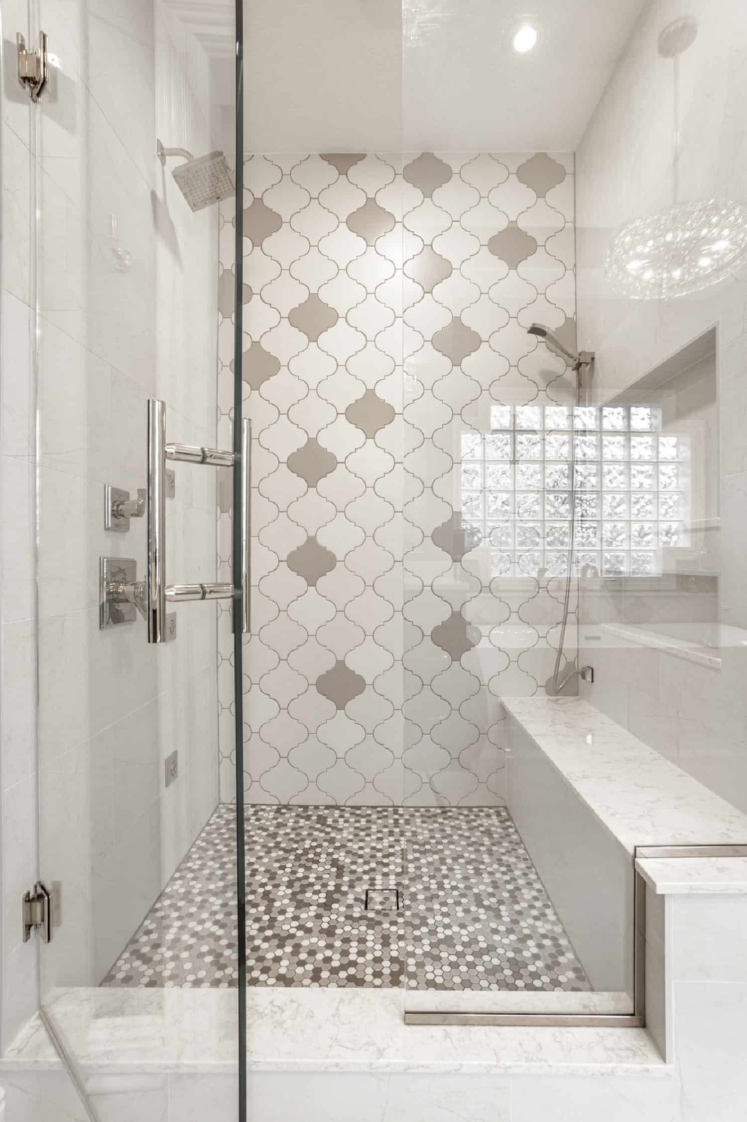 Nicholas Design Build | A white and gray bathroom with a glass shower door.