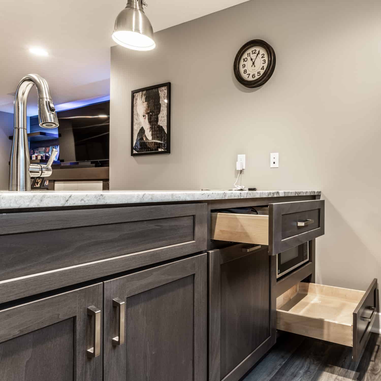 Nicholas Design Build | A kitchen with gray cabinets and a clock on the wall.