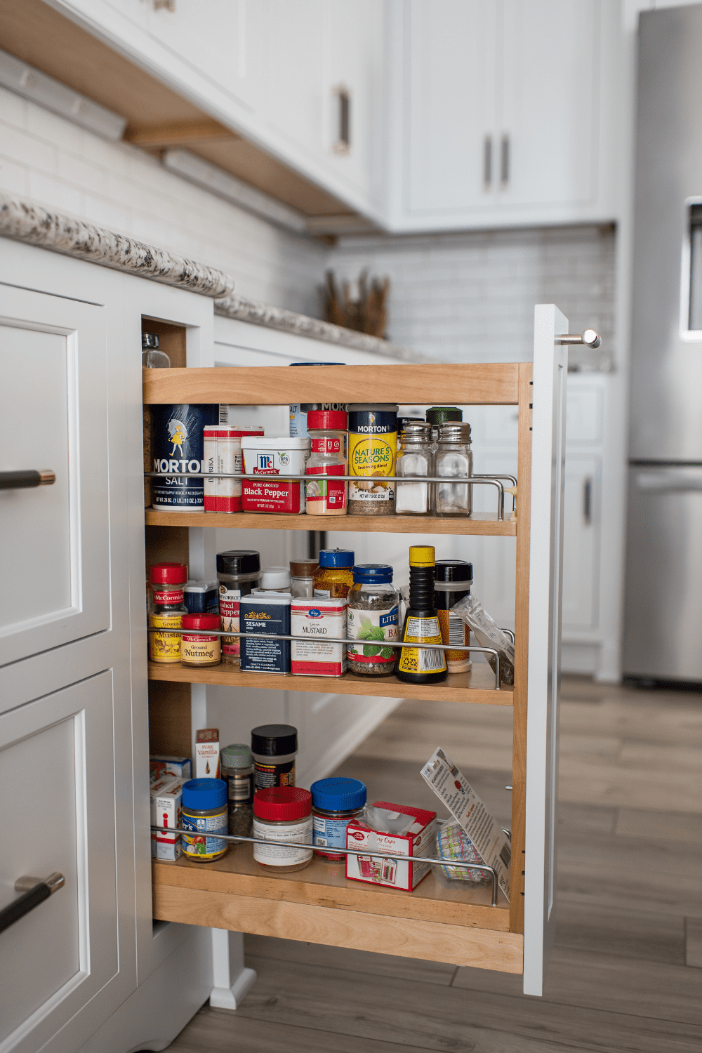 Nicholas Design Build | A kitchen cabinet with a spice rack in it.