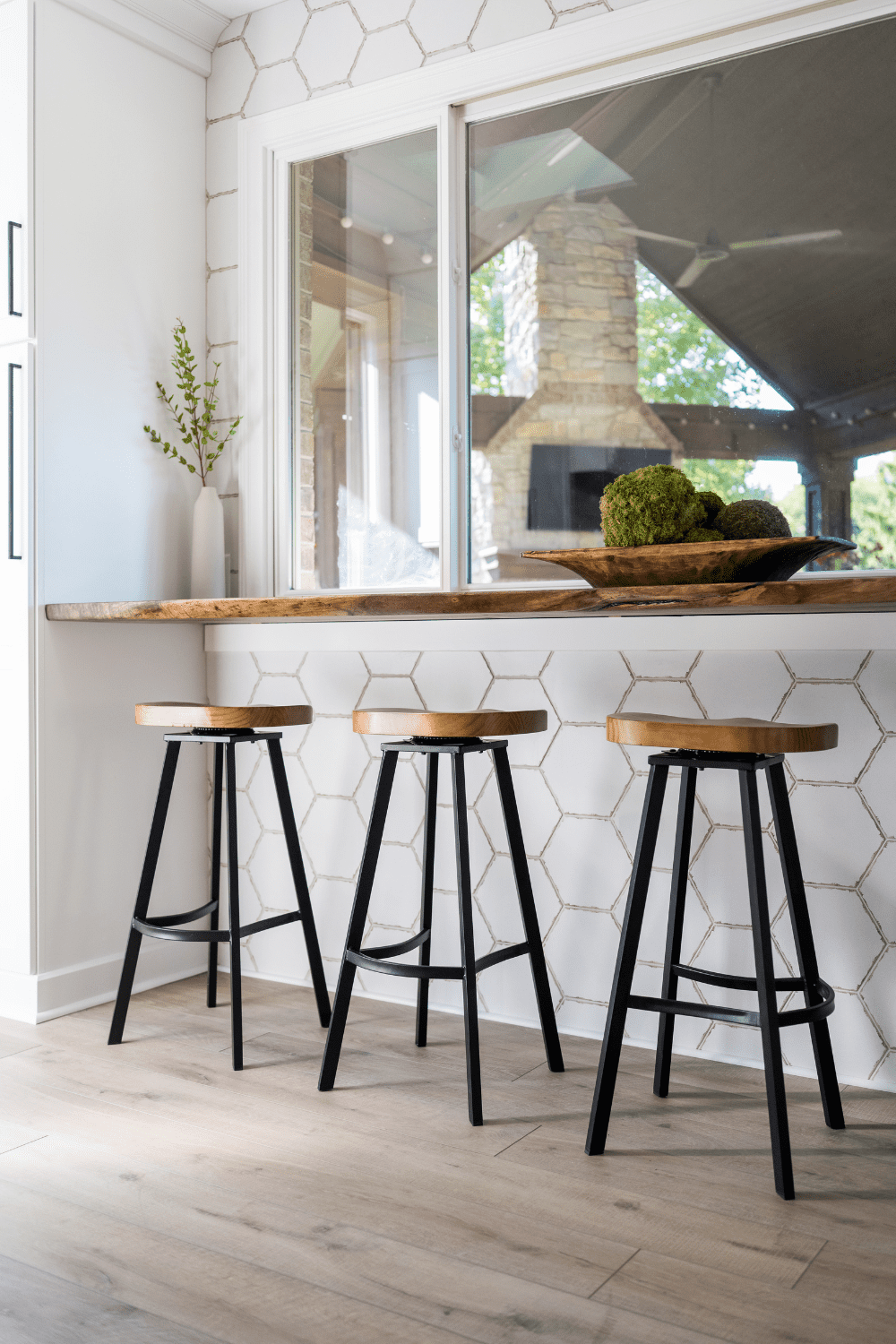 Nicholas Design Build | Three bar stools in a kitchen with white tile.