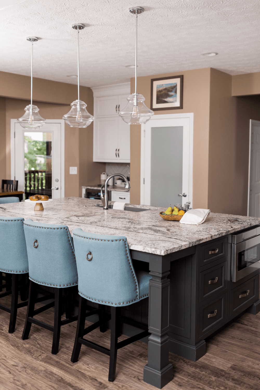 Nicholas Design Build | A versatile kitchen with a large island and blue chairs.