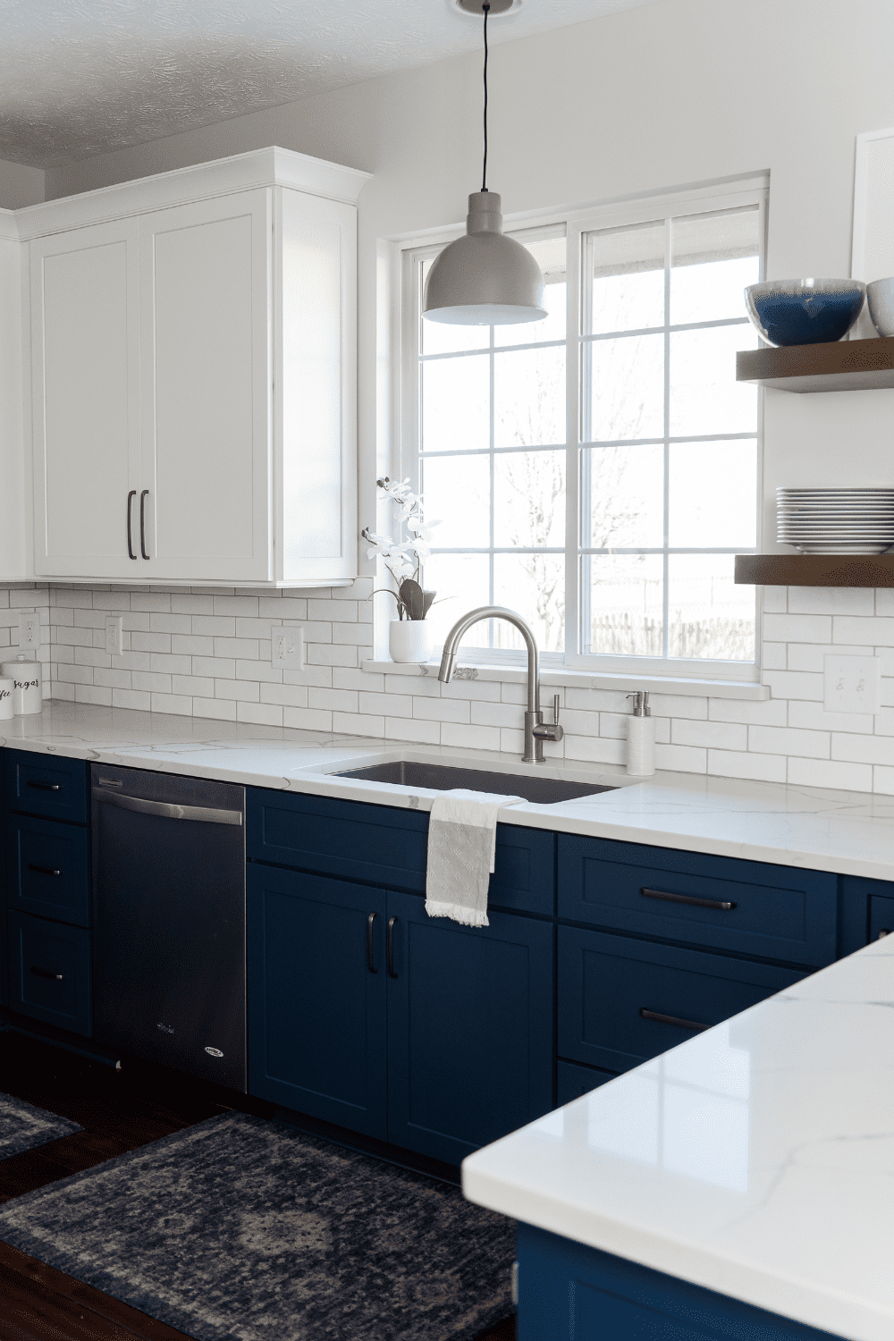 Nicholas Design Build | A kitchen with blue cabinets and white counter tops.