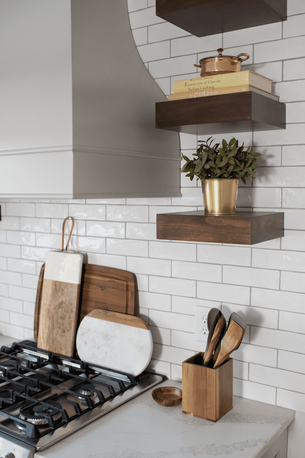 Nicholas Design Build | A neutral kitchen with wooden shelves and pots and pans.