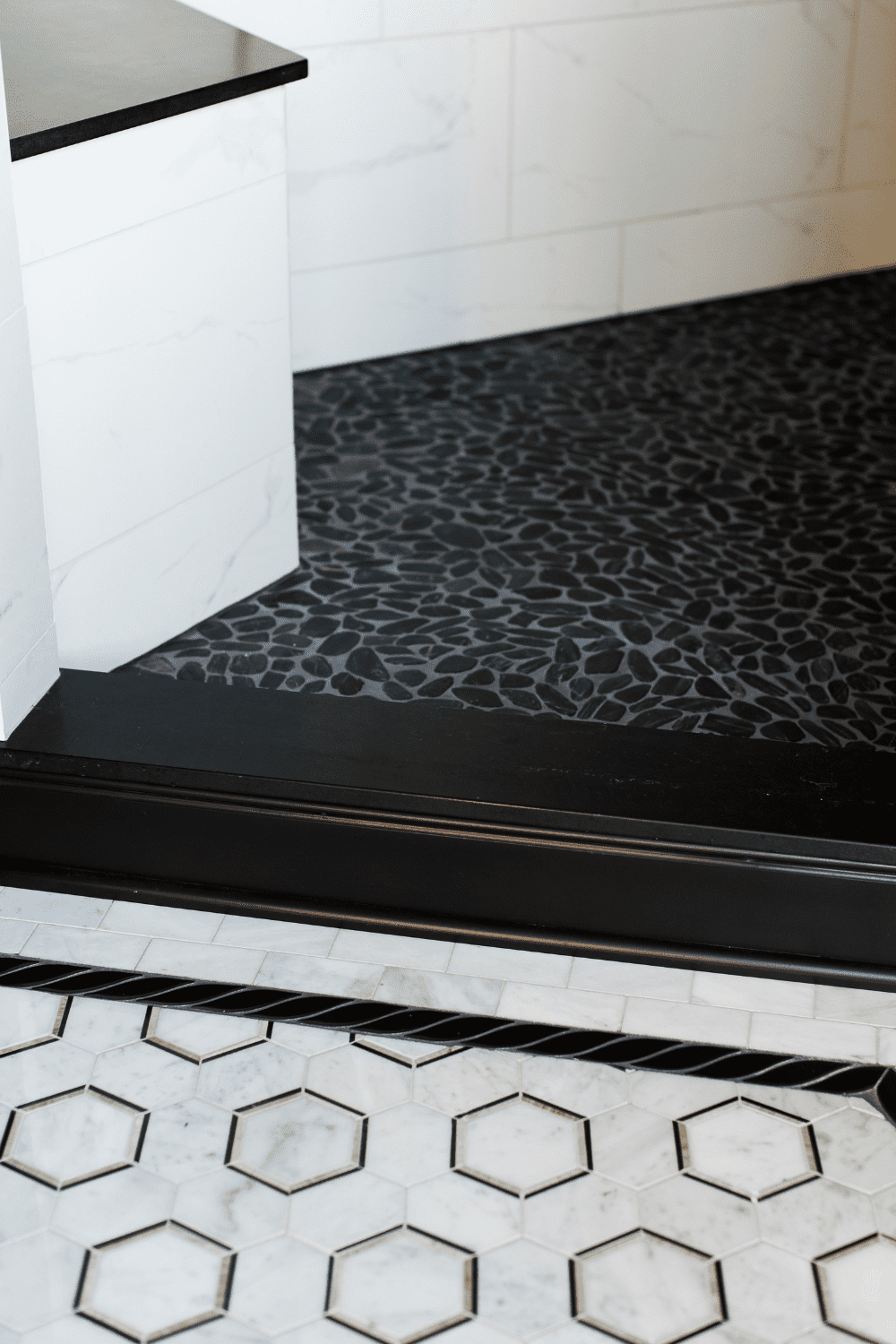 Nicholas Design Build | A bathroom with a black and white tile floor.