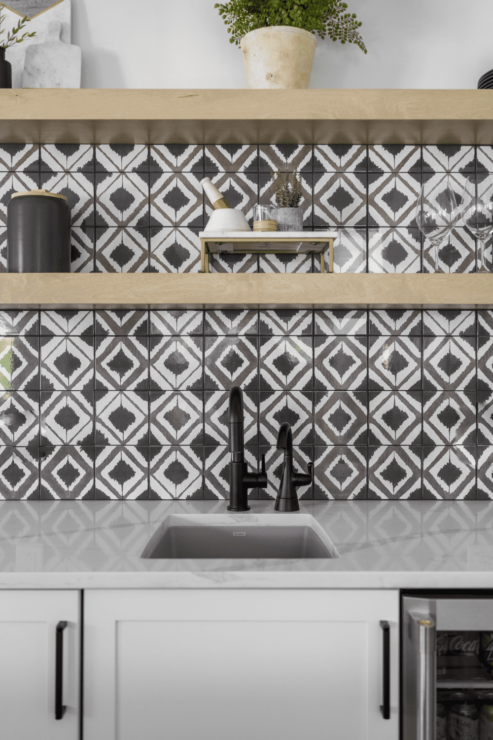 Nicholas Design Build | A kitchen with a black and white tile backsplash.