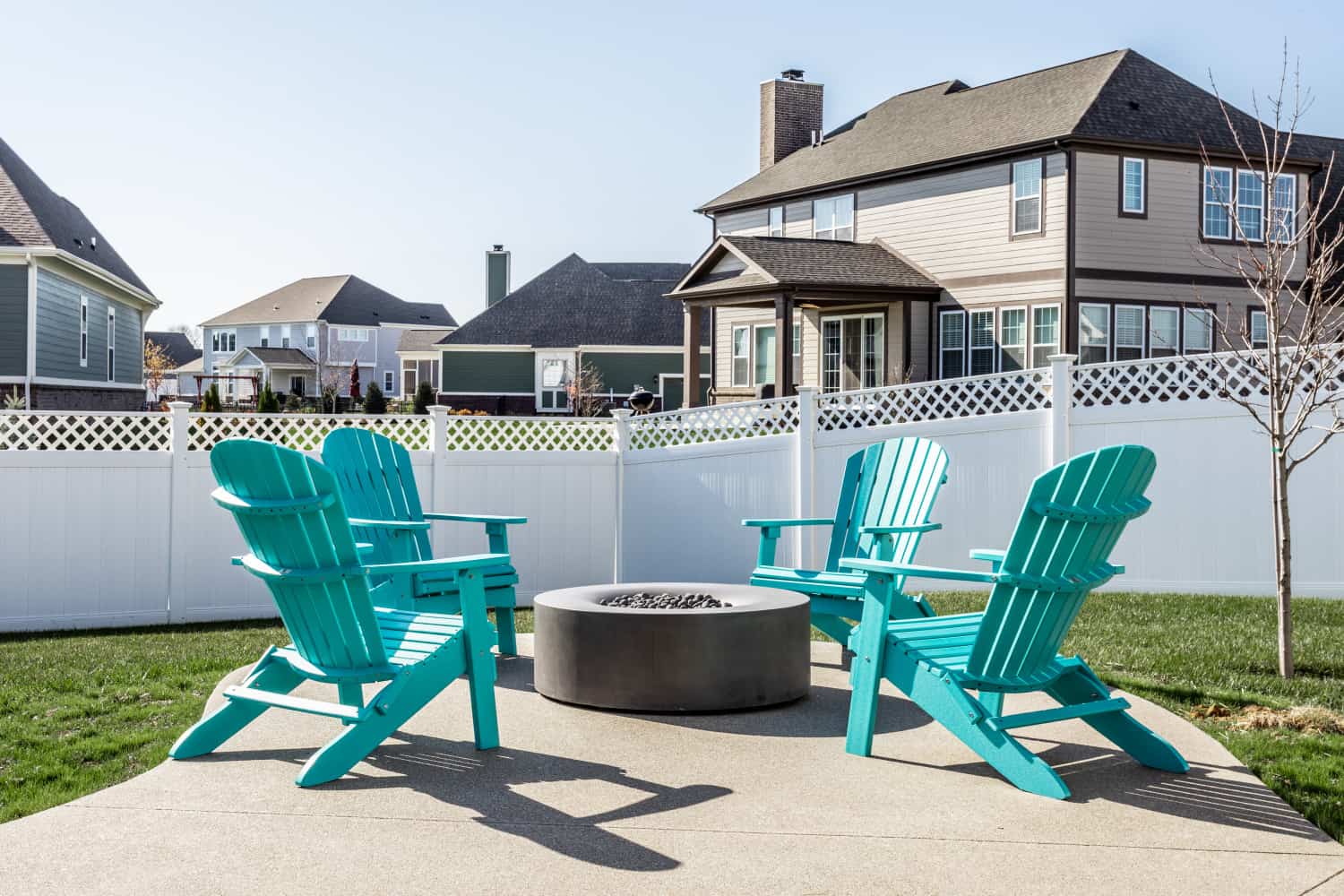 Nicholas Design Build | Remodeled backyard with Adirondack chairs and a fire pit.