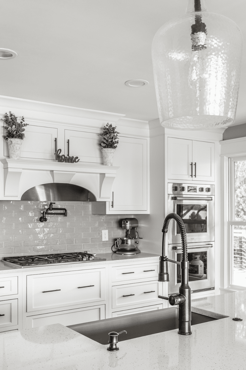 Nicholas Design Build | A black and white photo of a kitchen with white cabinets.
