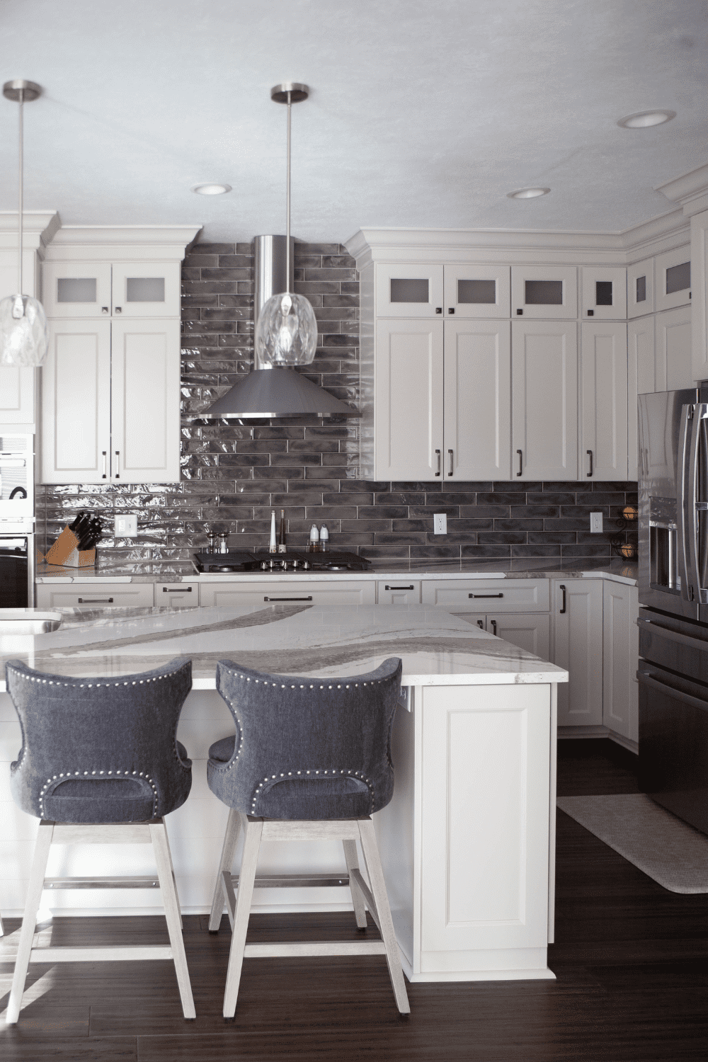 Nicholas Design Build | A kitchen with a center island and two stools.
