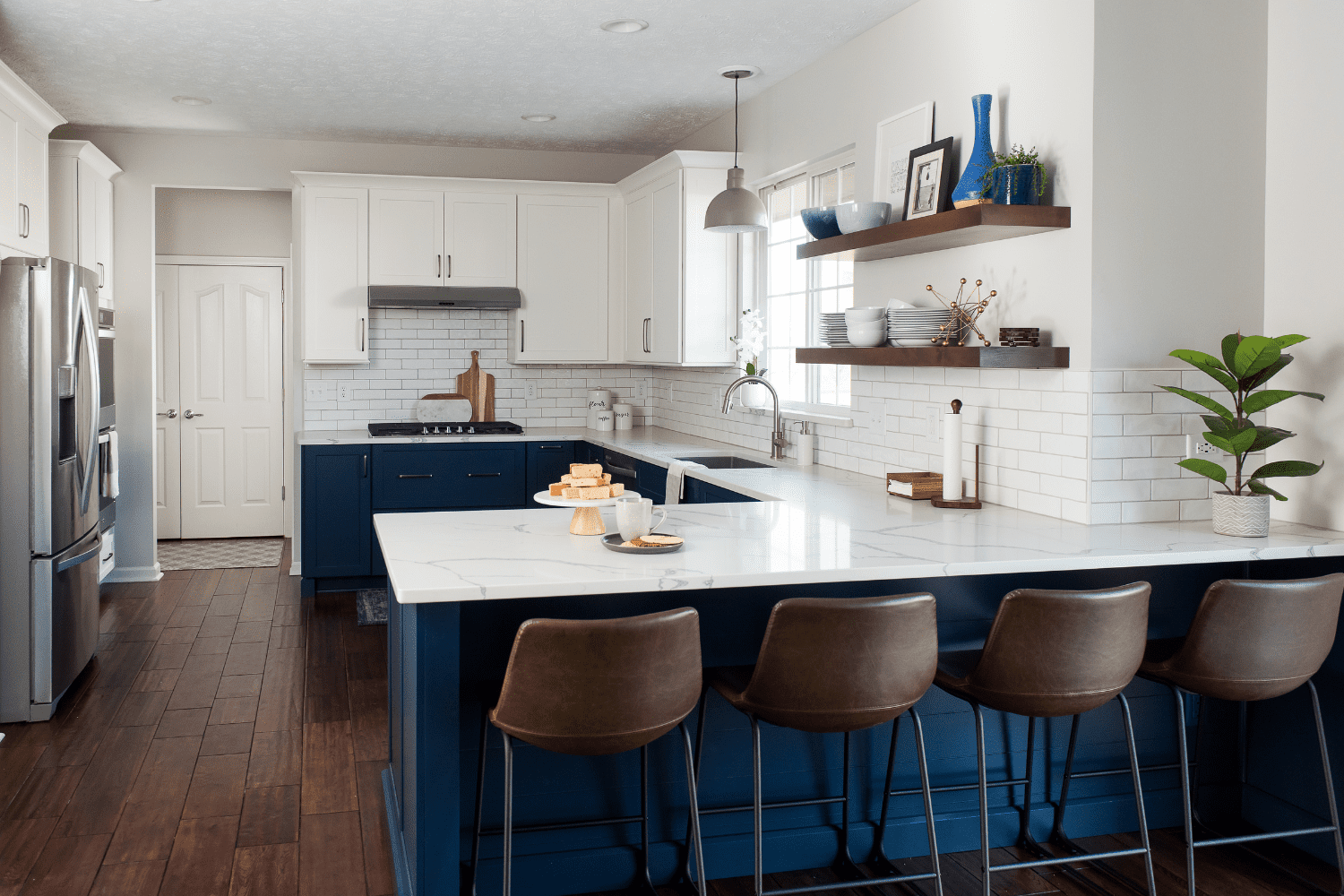Nicholas Design Build | A kitchen with blue cabinets and stools.