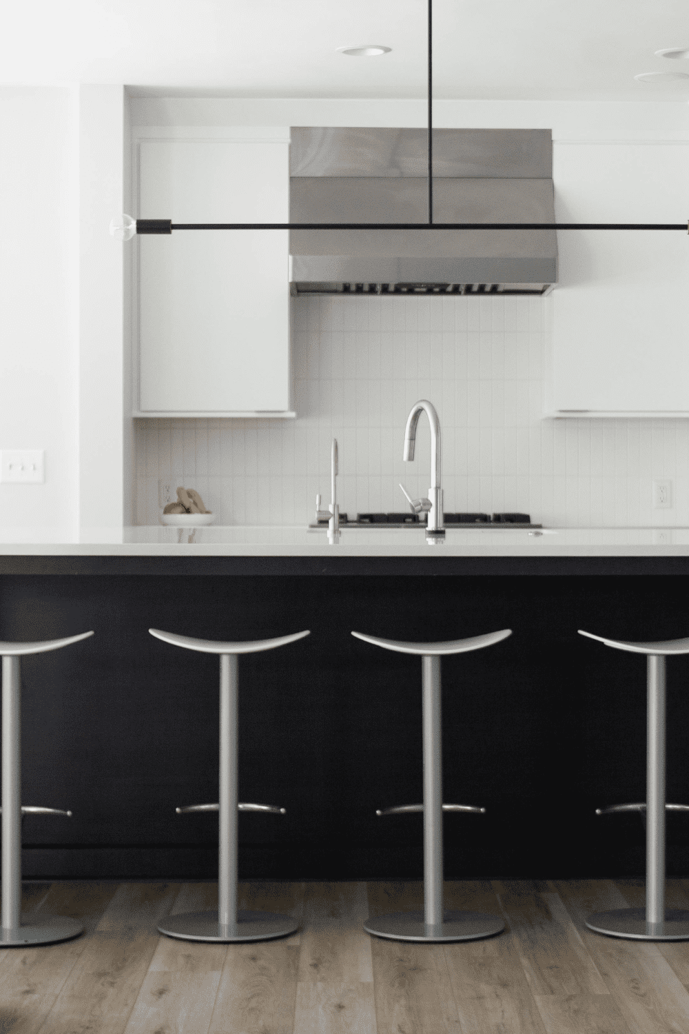 Nicholas Design Build | A black and white kitchen with bar stools.