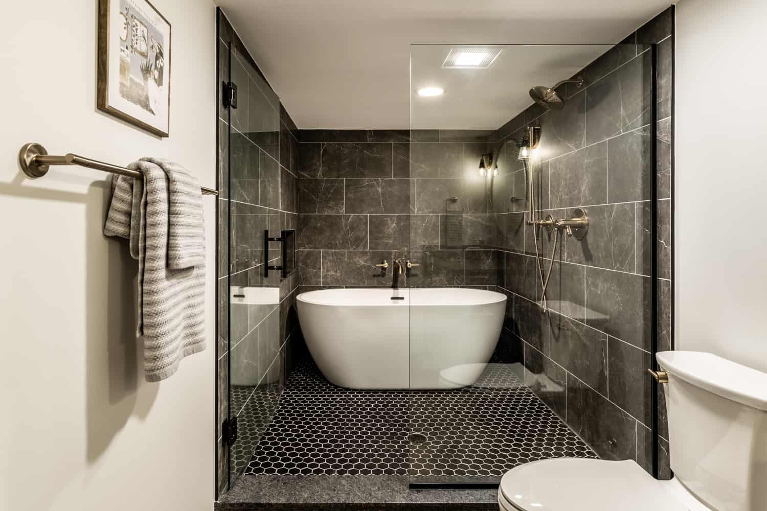 Nicholas Design Build | A remodeled bathroom with a bathtub, toilet and sink.