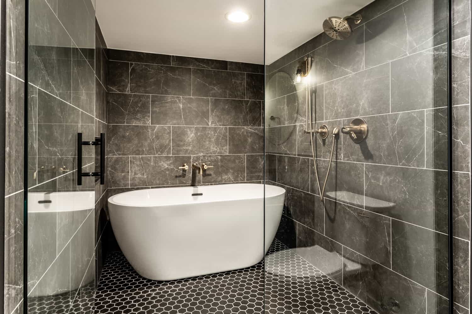 Nicholas Design Build | A newly remodeled bathroom with a bathtub and glass shower.
