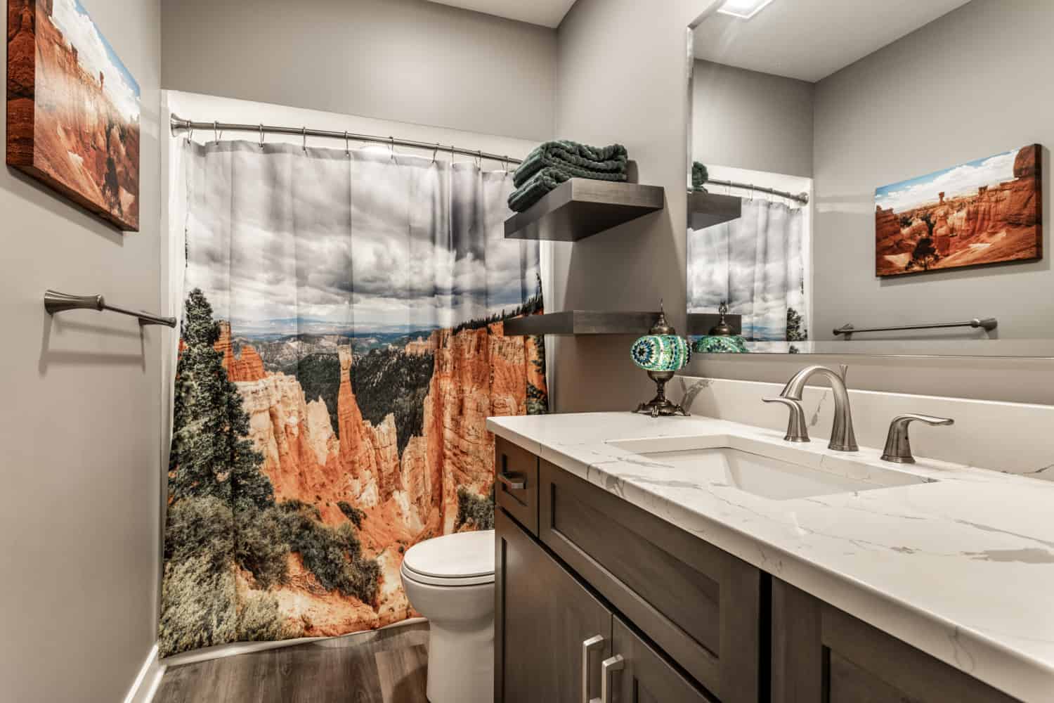 Nicholas Design Build | A remodeled bathroom with a shower curtain featuring a breathtaking view of Bryce Canyon.