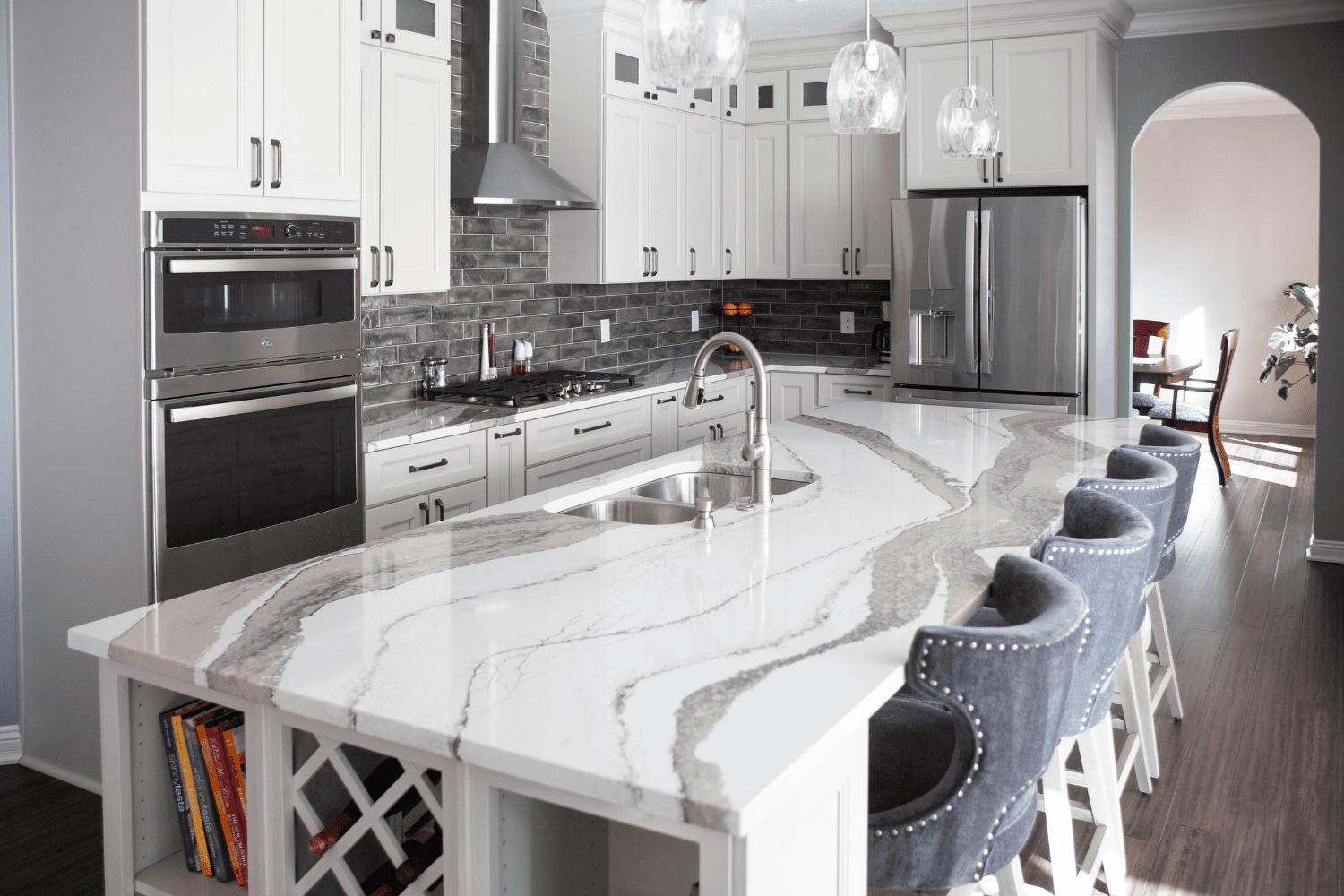 Nicholas Design Build | A kitchen with white cabinets and marble counter tops.