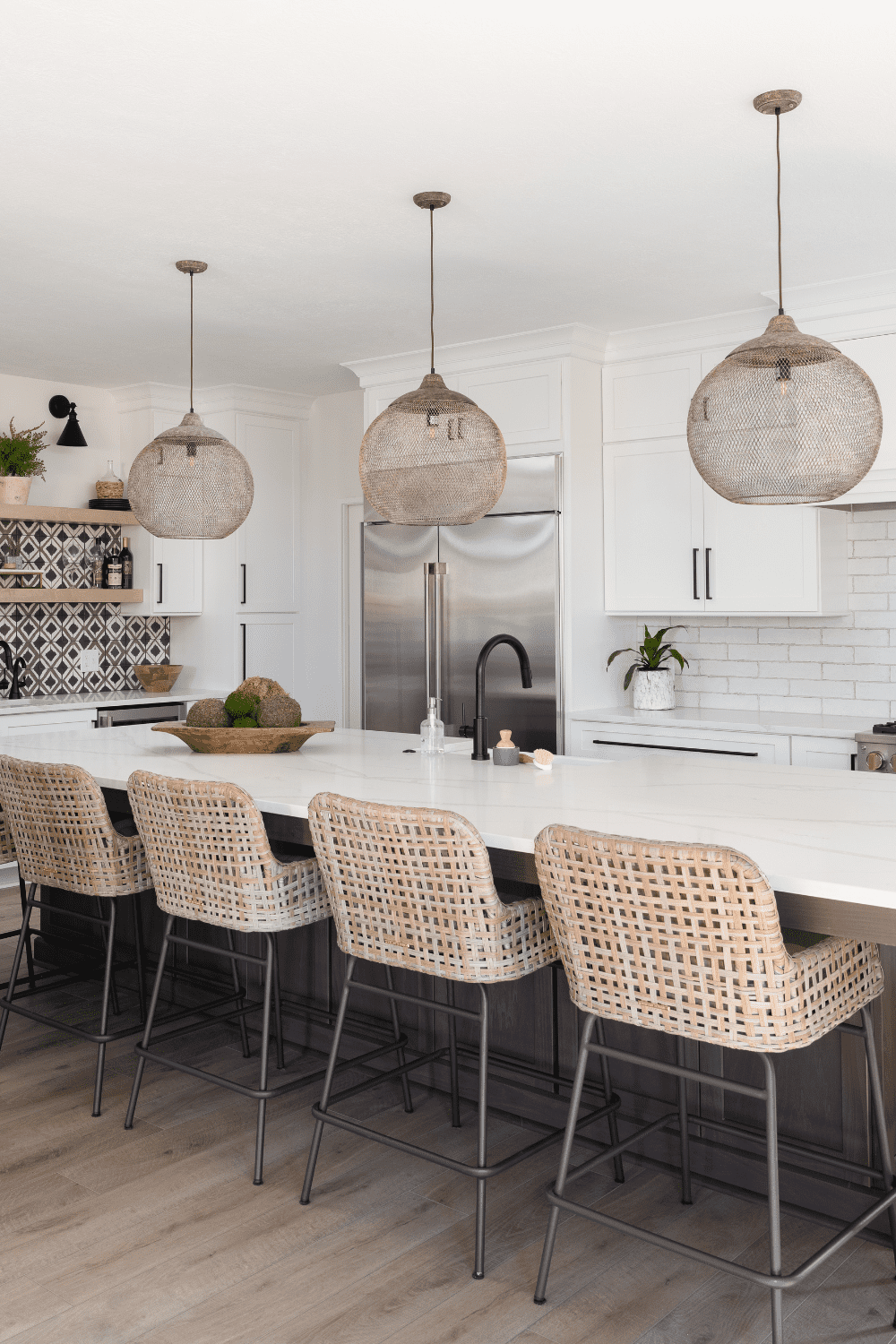 Nicholas Design Build | A kitchen with a large island and wicker chairs.