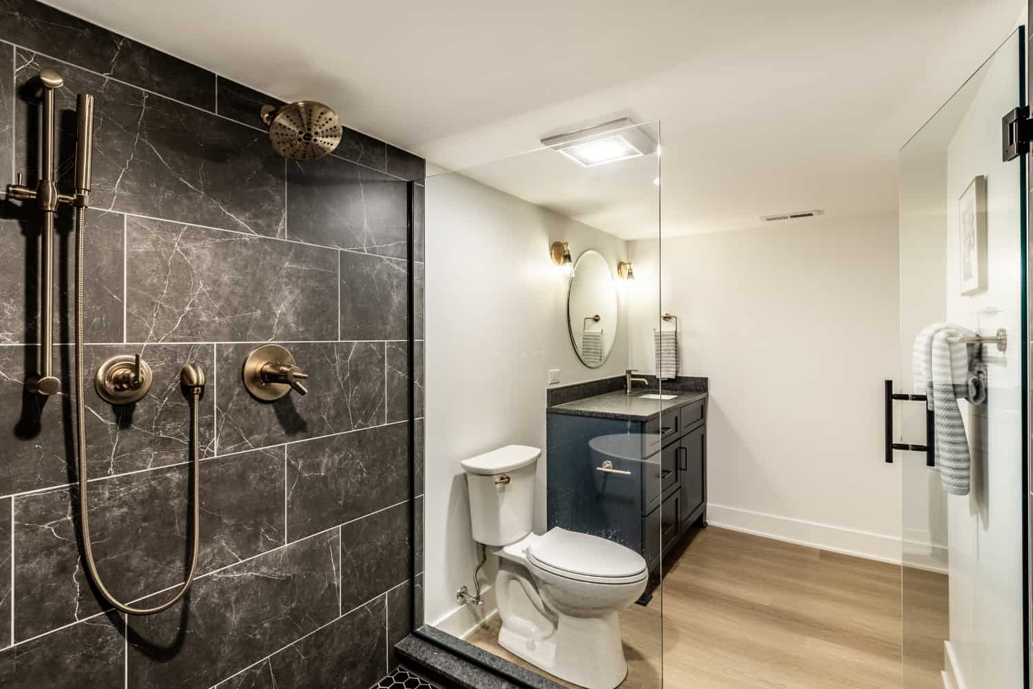 Nicholas Design Build | A remodeled bathroom with a shower, toilet, and sink.