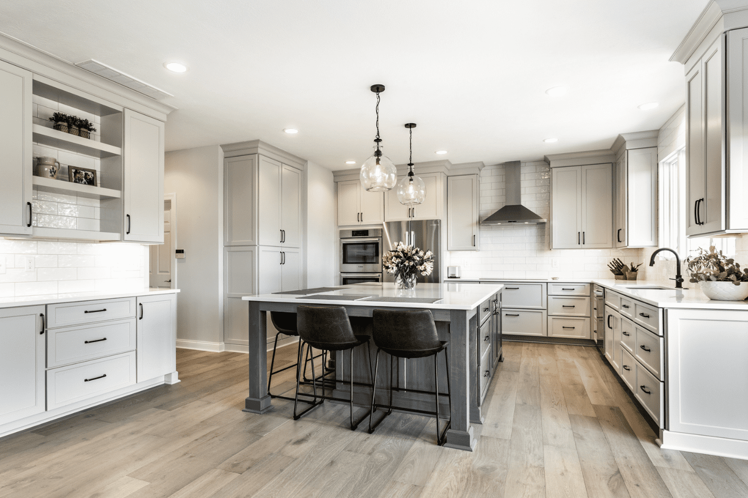 Nicholas Design Build | A kitchen with gray cabinets and hardwood floors.