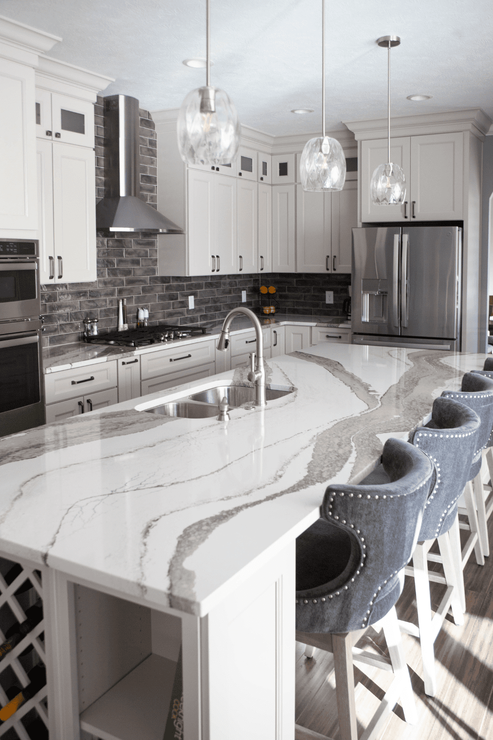 Nicholas Design Build | A kitchen with marble counter tops and bar stools.