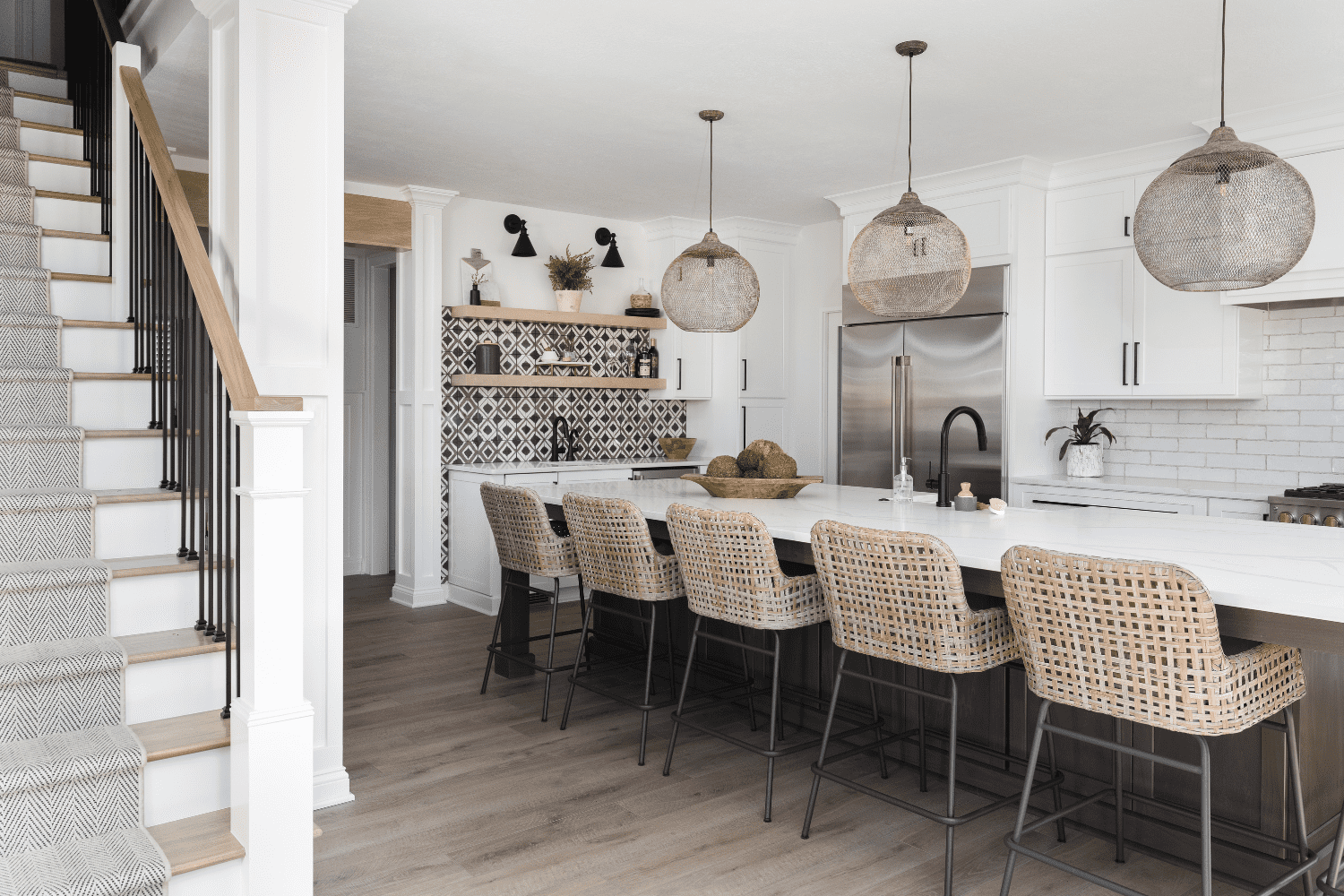Nicholas Design Build | A kitchen with a white island and wicker stools.