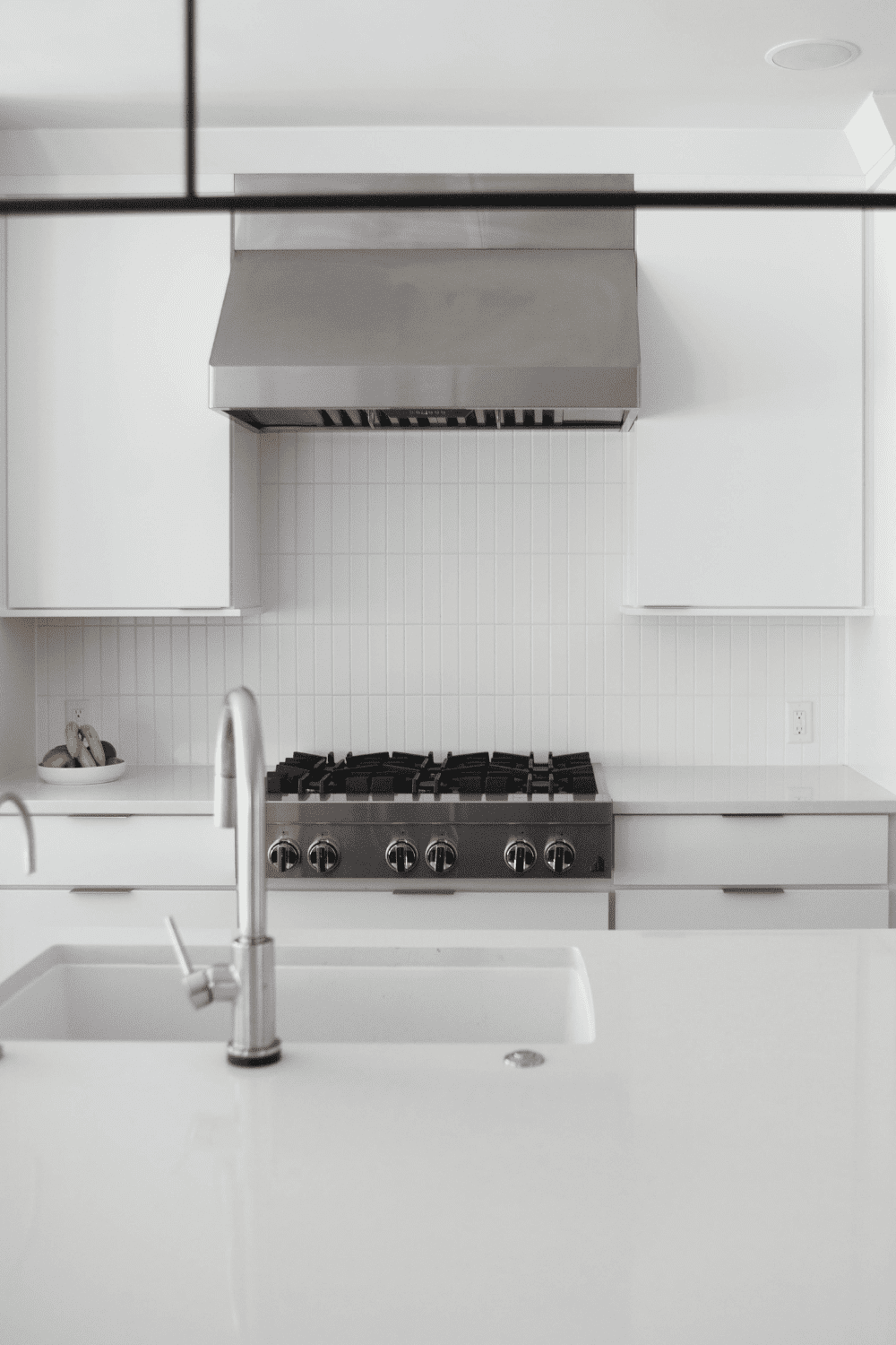 Nicholas Design Build | A white kitchen with a stove and sink.