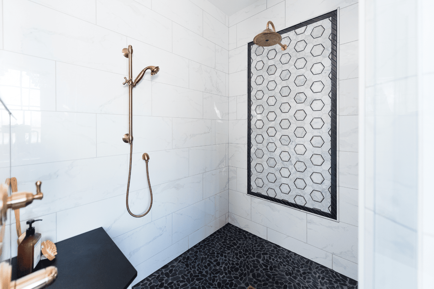 Nicholas Design Build | A black and white bathroom with a gold shower head.