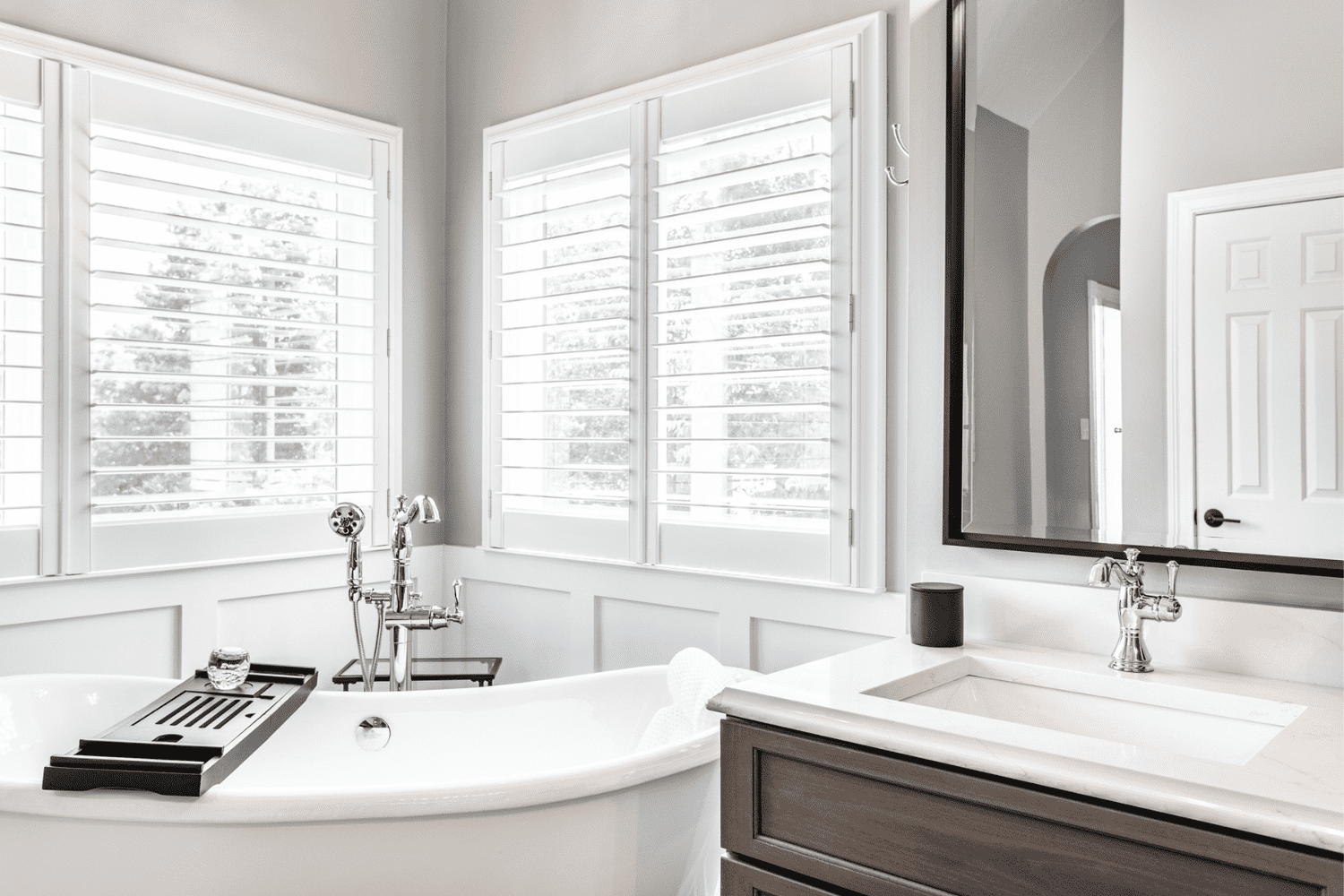 Nicholas Design Build | Master bath remodel: A black and white bathroom with a tub and sink.