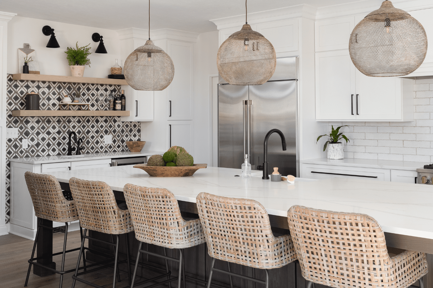 Nicholas Design Build | A kitchen with white cabinets and wicker stools.