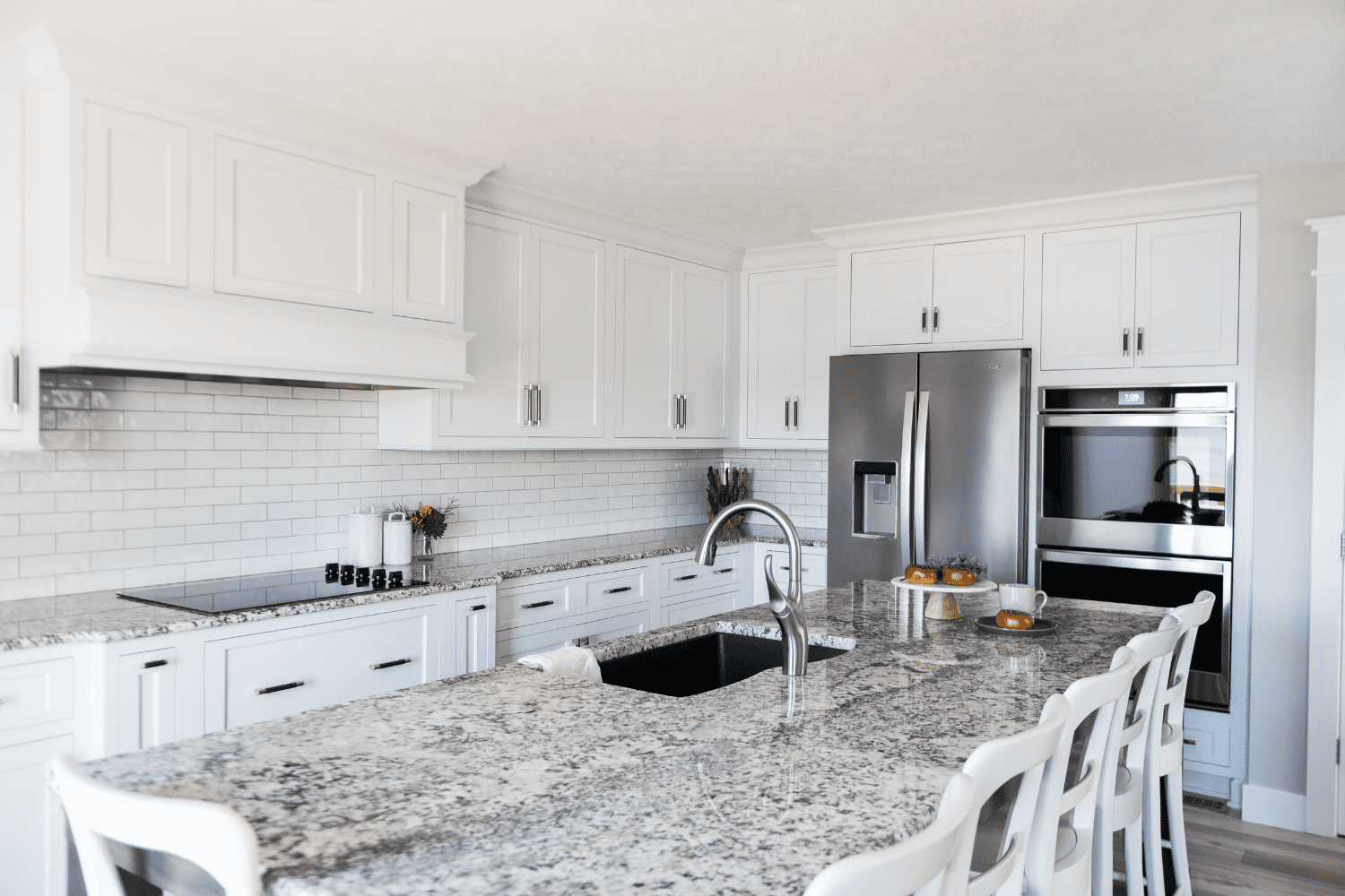 Nicholas Design Build | A kitchen with white cabinets and granite counter tops.