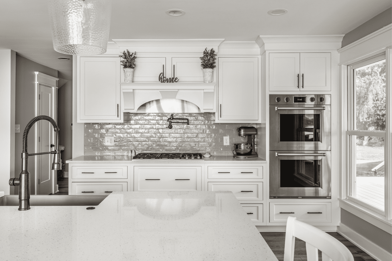 Nicholas Design Build | A black and white photo of a kitchen with white cabinets.