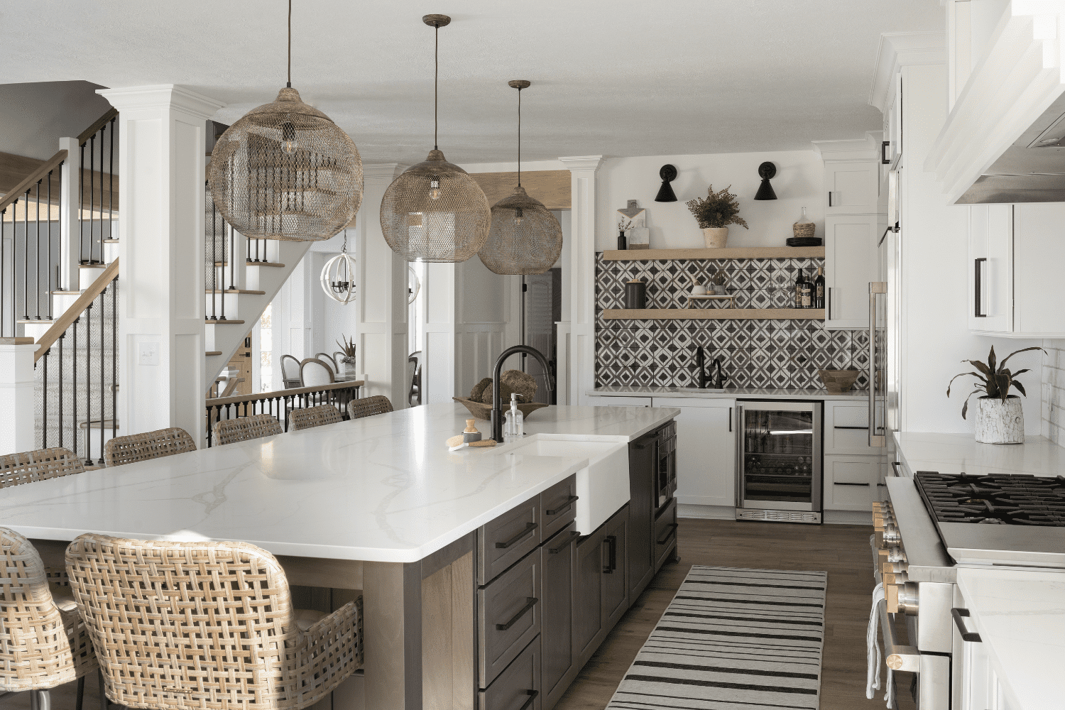 Nicholas Design Build | A kitchen with a white island and wicker chairs.